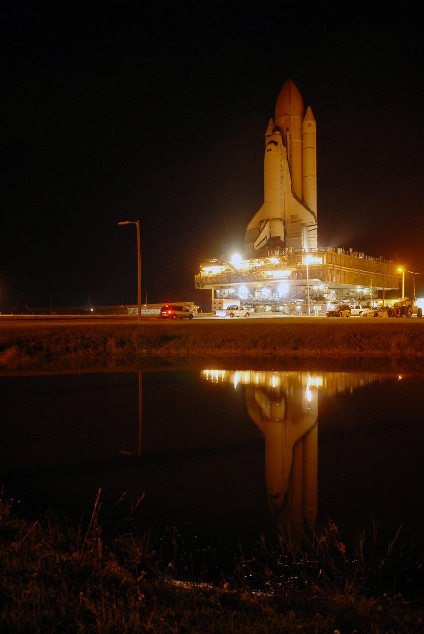CAPE CANAVERAL, Fla. -- At NASA's Kennedy Space Center, space shuttle Discovery, secured atop a mobile launch platform, is reflected in water beside the crawlerway as it is moved from the Vehicle Assembly Building to Launch Pad 39A to prepare for the STS-124 mission.  The 3.4-mile journey from the Vehicle Assembly Building began at 11:47 p.m. on May 2.  The shuttle arrived at the launch pad at 4:25 a.m. EDT May 3 and was secured, or hard down, by 6:06 a.m.  On the 13-day mission, Discovery and its crew will deliver the Japan Aerospace Exploration Agency's Japanese Experiment Module – Pressurized Module and the Japanese Remote Manipulator System. Launch is targeted for May 31.  Photo credit: NASA/Troy Cryder