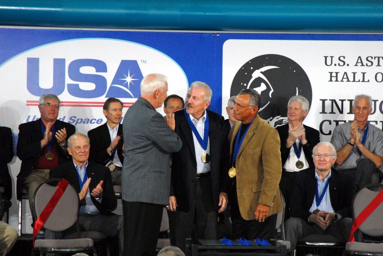 CAPE CANAVERAL, Fla. -- Former astronaut Loren Shriver (center) is inducted into the U.S. Astronaut Hall of Fame May 3 at NASA's Kennedy Space Center. Presenting the medal are former inductees Al Worden (left) and Charles Bolden (right). Other inductees were John Blaha; Bryan O'Connor, NASA's chief of Safety and Mission Assurance at NASA Headquarters in Washington; and Bob Cabana, center director of NASA's Stennis Space Center in Mississippi. Other former astronauts attending included Scott Carpenter, John Young, Bob Crippen, and Walt Cunningham. The U.S. Astronaut Hall of Fame is operated by Kennedy Space Center Visitor Complex on behalf of NASA. CNN correspondent John Zarrella hosted the event.