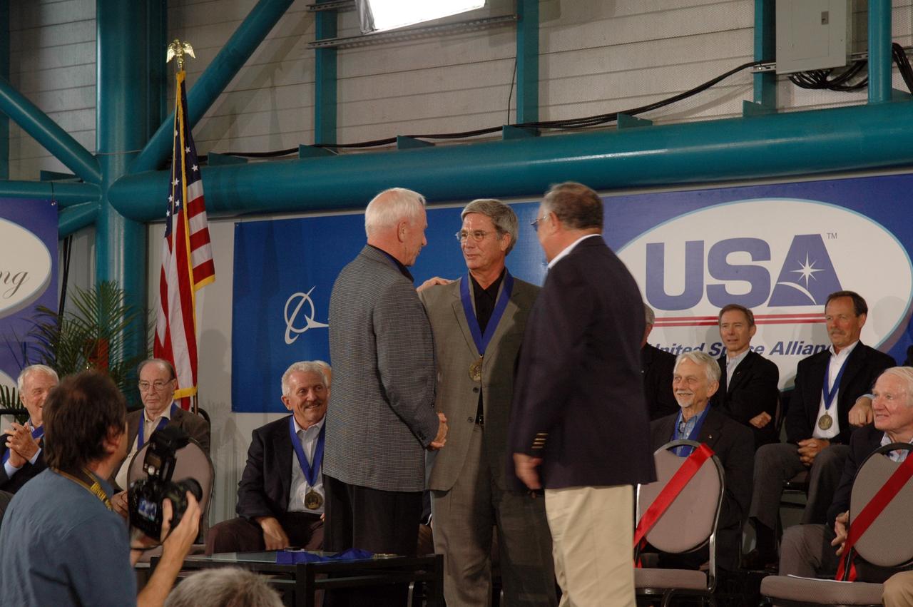 CAPE CANAVERAL, Fla. -- Former astronaut John Blaha (center) receives congratulations on his induction into the U.S. Astronaut Hall of Fame May 3 at NASA's Kennedy Space Center from former inductees Al Worden (left) and Fred Gregory (right). Other inductees were Loren Shriver; Bryan O'Connor, NASA's chief of Safety and Mission Assurance at NASA Headquarters in Washington; and Bob Cabana, center director of NASA's Stennis Space Center in Mississippi. Other former astronauts attending included Scott Carpenter, John Young, Bob Crippen, and Walt Cunningham. The U.S. Astronaut Hall of Fame is operated by Kennedy Space Center Visitor Complex on behalf of NASA. CNN correspondent John Zarrella hosted the event.