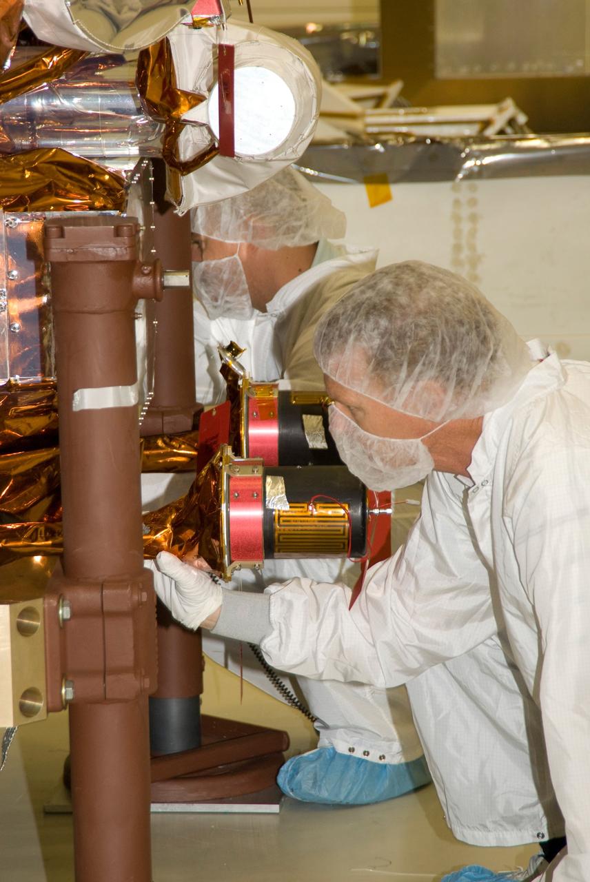 CAPE CANAVERAL, Fla. --  At the Astrotech payload processing facility in Titusville, Fla., technicians check the  NASA's Gamma-ray Large Area Space Telescope, or GLAST, spacecraft after being lowered toward the transporter.  The spacecraft is being prepared for its move to the Hazardous Processing Facility for fueling. The GLAST is a powerful space observatory that will explore the universe's ultimate frontier, where nature harnesses forces and energies far beyond anything possible on Earth;  probe some of science's deepest questions, such as what our Universe is made of, and search for new laws of physics; explain how black holes accelerate jets of material to nearly light speed; and help crack the mystery of stupendously powerful explosions known as gamma-ray bursts. A launch date is still to be determined.  Photo credit: NASA/Mike Kerley