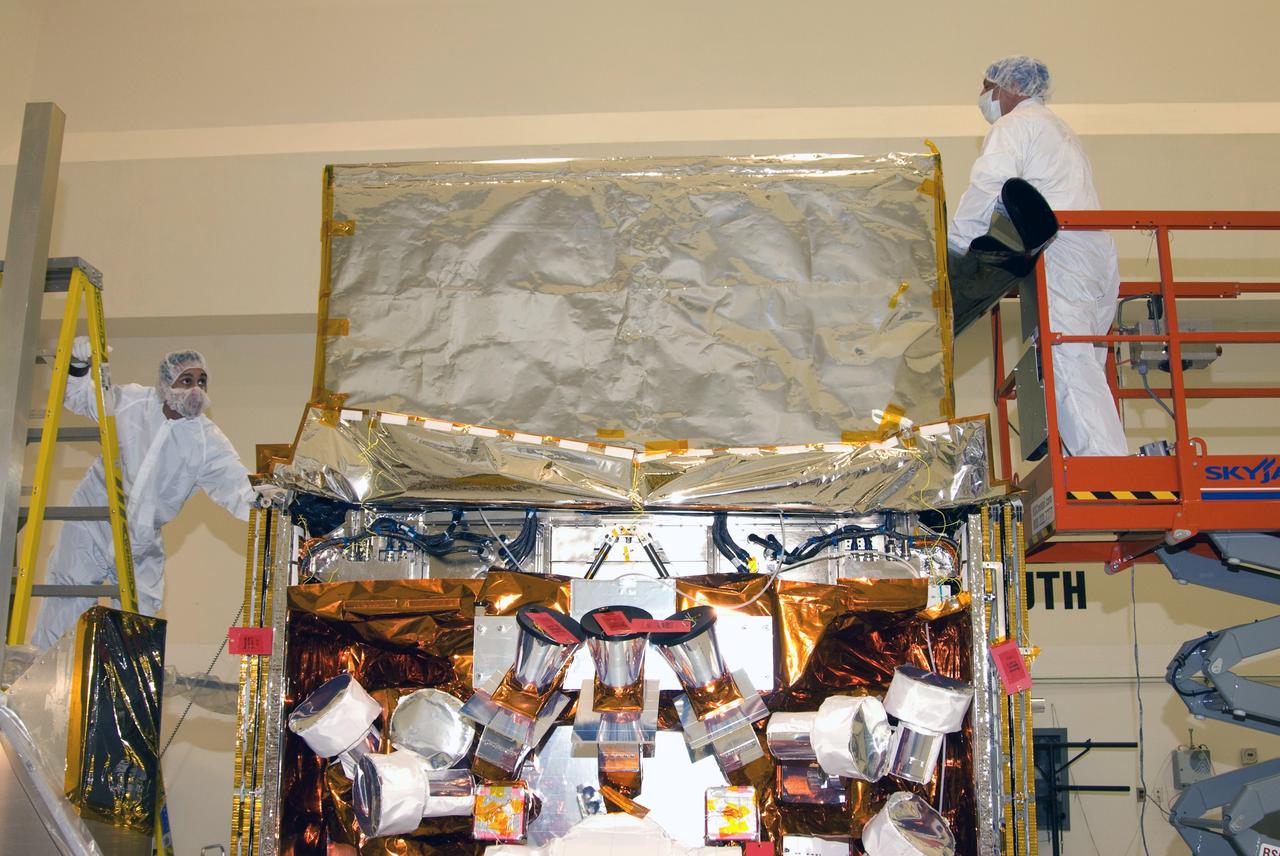 CAPE CANAVERAL, Fla. --  At the Astrotech payload processing facility in Titusville, Fla., technicians begin placing a protective cover over NASA's Gamma-ray Large Area Space Telescope, or GLAST, spacecraft.  GLAST is being prepared for its move to the Hazardous Processing Facility for fueling. The GLAST is a powerful space observatory that will explore the universe's ultimate frontier, where nature harnesses forces and energies far beyond anything possible on Earth;  probe some of science's deepest questions, such as what our Universe is made of, and search for new laws of physics; explain how black holes accelerate jets of material to nearly light speed; and help crack the mystery of stupendously powerful explosions known as gamma-ray bursts. A launch date is still to be determined.  Photo credit: NASA/Mike Kerley