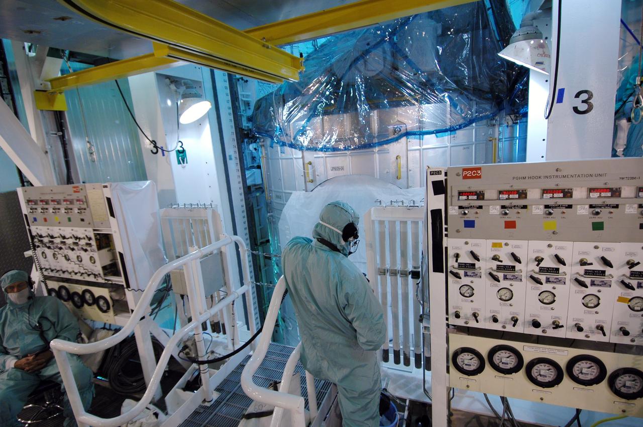 CAPE CANAVERAL, Fla. -- Technicians in the Payload Changeout Room on Launch Pad 39A at NASA's Kennedy Space Center monitor the transfer of the STS-124 mission payload, the Japanese Experiment Module - Pressurized Module and the Japanese Remote Manipulator System into space shuttle Discovery's payload bay. Launch of Discovery is targeted for May 31. Photo credit: NASA/Jim Grossmann
