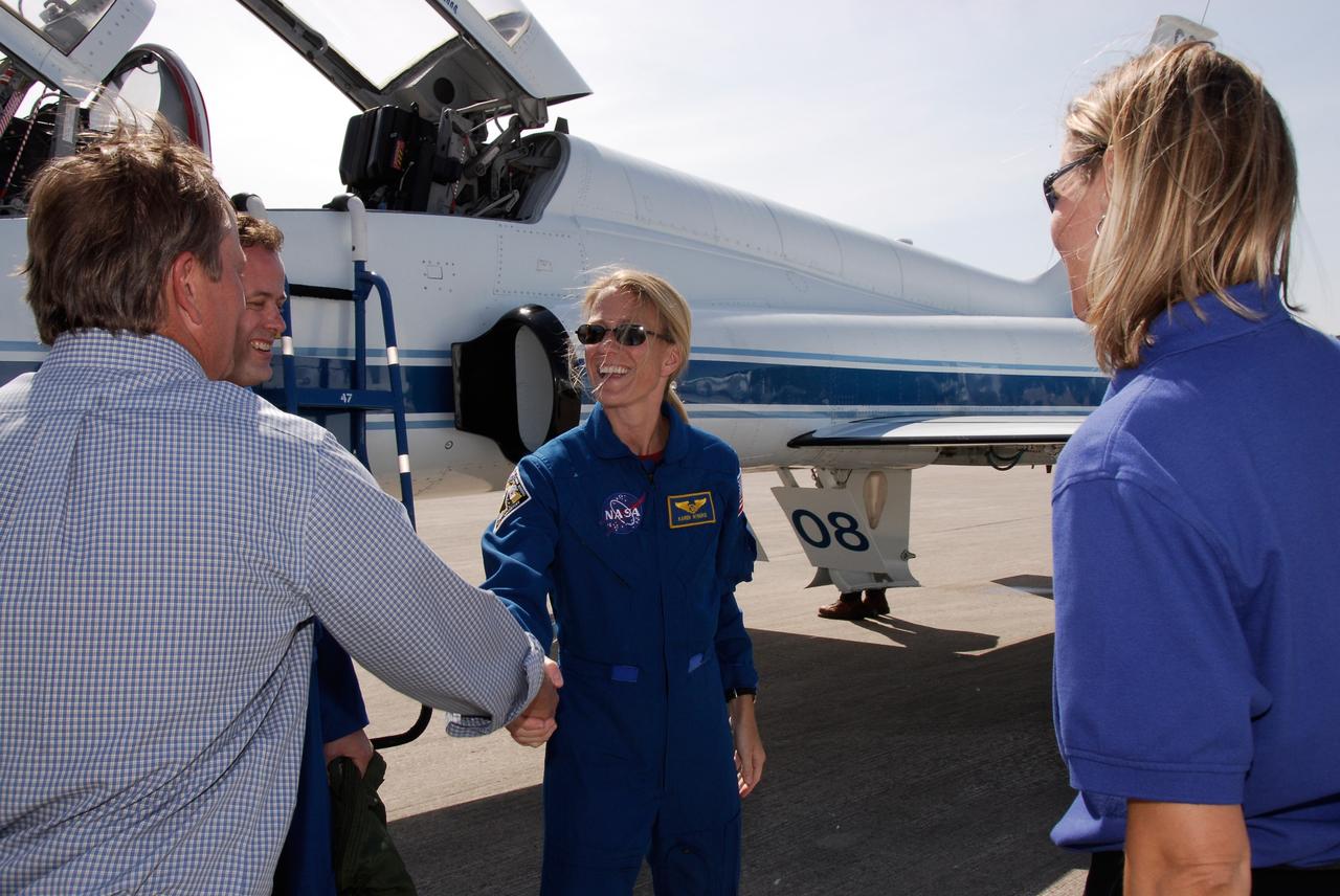 CAPE CANAVERAL, Fla. --  The crew of space shuttle Discovery's STS-124 mission arrive at NASA Kennedy Space Center's Shuttle Landing Facility to take part in the Terminal Countdown Demonstration Test, or TCDT.  Here Shuttle Launch Director Mike Leinbach (left) greets Mission Specialist Karen Nyberg.  Between them is Mission Specialist Ron Garan.  At right is NASA Flow Director for Discovery Stephanie Stilson. TCDT is a rehearsal for launch that includes practicing emergency procedures, handling on-orbit equipment, and simulating a launch countdown. On the STS-124 mission, the crew will deliver and install the Japanese Experiment Module – Pressurized Module and Japanese Remote Manipulator System.  Discovery's launch is targeted for May 31.  Photo credit: NASA/Kim Shiflett