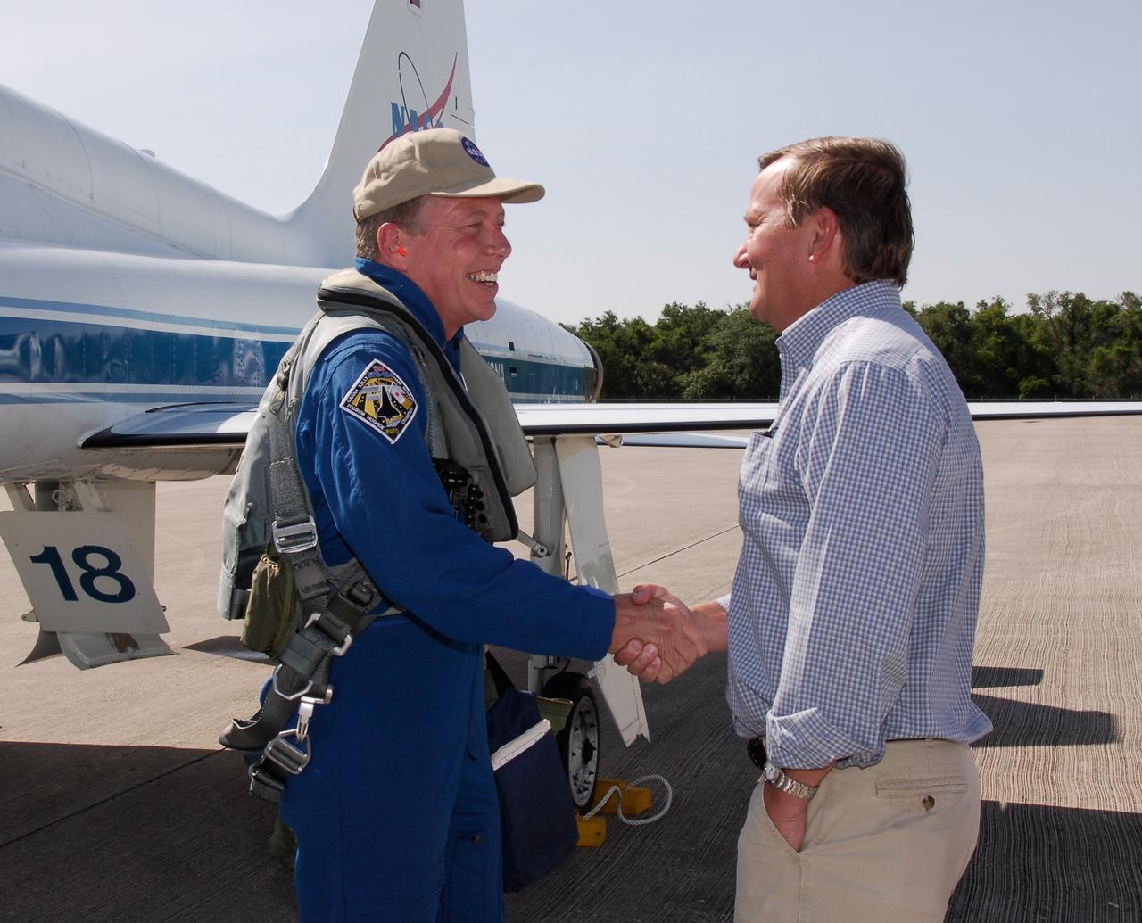 CAPE CANAVERAL, Fla. --  The crew of space shuttle Discovery's STS-124 mission arrive at NASA Kennedy Space Center's Shuttle Landing Facility to take part in the Terminal Countdown Demonstration Test, or TCDT. Mission Specialist Mike Fossum is greeted by Shuttle Launch Director Mike Leinbach. TCDT is a rehearsal for launch that includes practicing emergency procedures, handling on-orbit equipment, and simulating a launch countdown. On the STS-124 mission, the crew will deliver and install the Japanese Experiment Module – Pressurized Module and Japanese Remote Manipulator System.  Discovery's launch is targeted for May 31.  Photo credit: NASA/Kim Shiflett