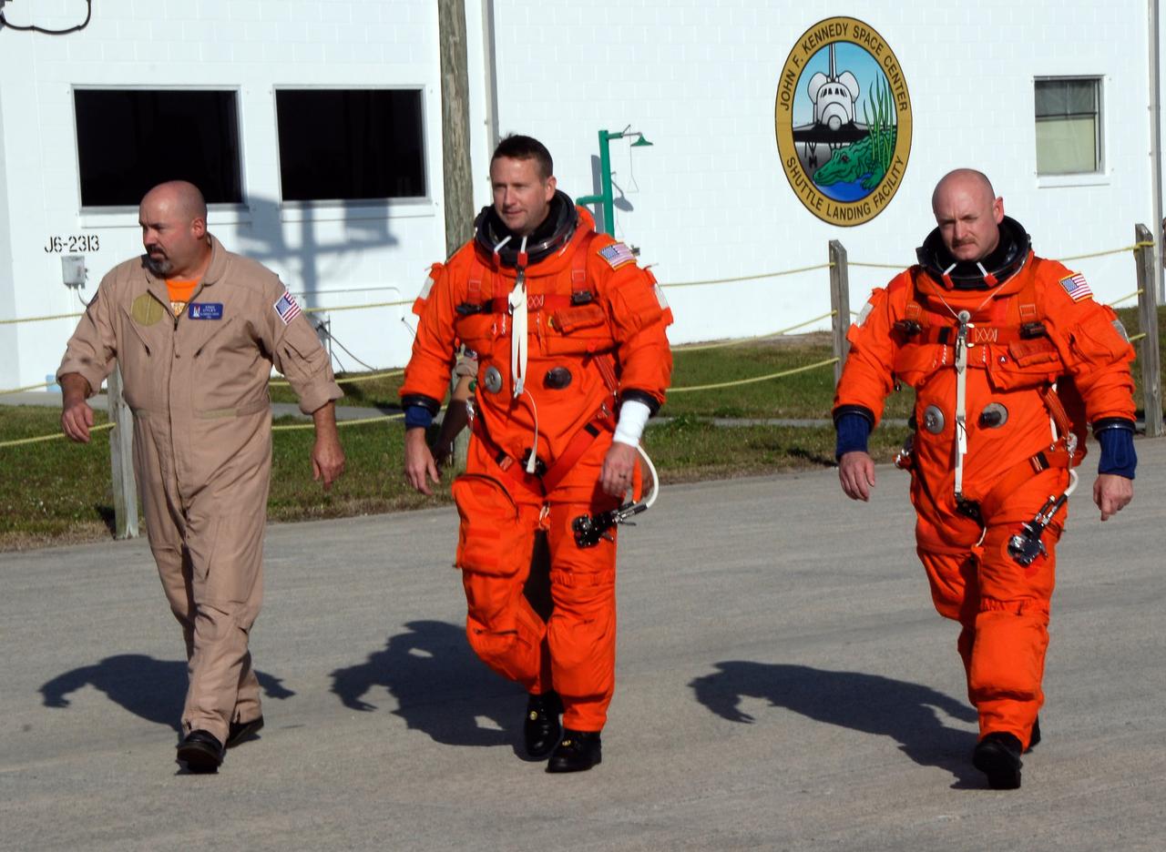 CAPE CANAVERAL, Fla. --  After their arrival at the NASA Kennedy Space Center Shuttle Landing Facility, STS-124 Pilot Ken Ham (center) and Commander Mark Kelly (right) head for the runway to practice space shuttle landings using NASA's Shuttle Training Aircraft, or STA.  The STA is a Grumman American Aviation-built Gulf Stream II jet that was modified to simulate an orbiter's cockpit, motion and visual cues, and handling qualities. In flight, the STA duplicates the orbiter's atmospheric descent trajectory from approximately 35,000 feet altitude to landing on a runway. Because the orbiter is unpowered during re-entry and landing, its high-speed glide must be perfectly executed the first time. The crew for space shuttle Discovery's STS-124 mission is at Kennedy for a full launch dress rehearsal, known as the terminal countdown demonstration test, or TCDT.  Providing astronauts and ground crews with an opportunity to participate in various simulated countdown activities, TCDT includes equipment familiarization and emergency training.  Discovery's launch is targeted for May 31.   Photo credit: NASA/Kim Shiflett