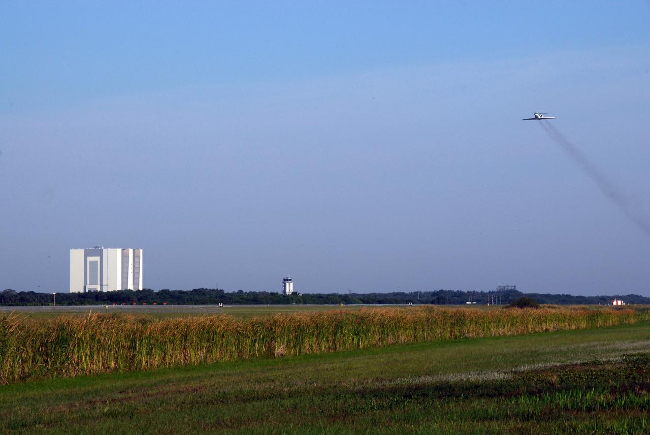 CAPE CANAVERAL, Fla. -- NASA's Shuttle Training Aircraft, or STA, soars into the sky (at right) over the NASA Kennedy Space Center Shuttle Landing Facility. At the controls is either STS-124 Commander Mark Kelly or Pilot Ken Ham, who are practicing space shuttle landings. At left, in the background, is the Vehicle Assembly Building. The STA is a Grumman American Aviation-built Gulf Stream II jet that was modified to simulate an orbiter's cockpit, motion and visual cues, and handling qualities. In flight, the STA duplicates the orbiter's atmospheric descent trajectory from approximately 35,000 feet altitude to landing on a runway. Because the orbiter is unpowered during re-entry and landing, its high-speed glide must be perfectly executed the first time. The crew for space shuttle Discovery's STS-124 mission is at Kennedy for a full launch dress rehearsal, known as the terminal countdown demonstration test, or TCDT. Providing astronauts and ground crews with an opportunity to participate in various simulated countdown activities, TCDT includes equipment familiarization and emergency training. Discovery's launch is targeted for May 31. Photo credit: NASA/Kim Shiflett