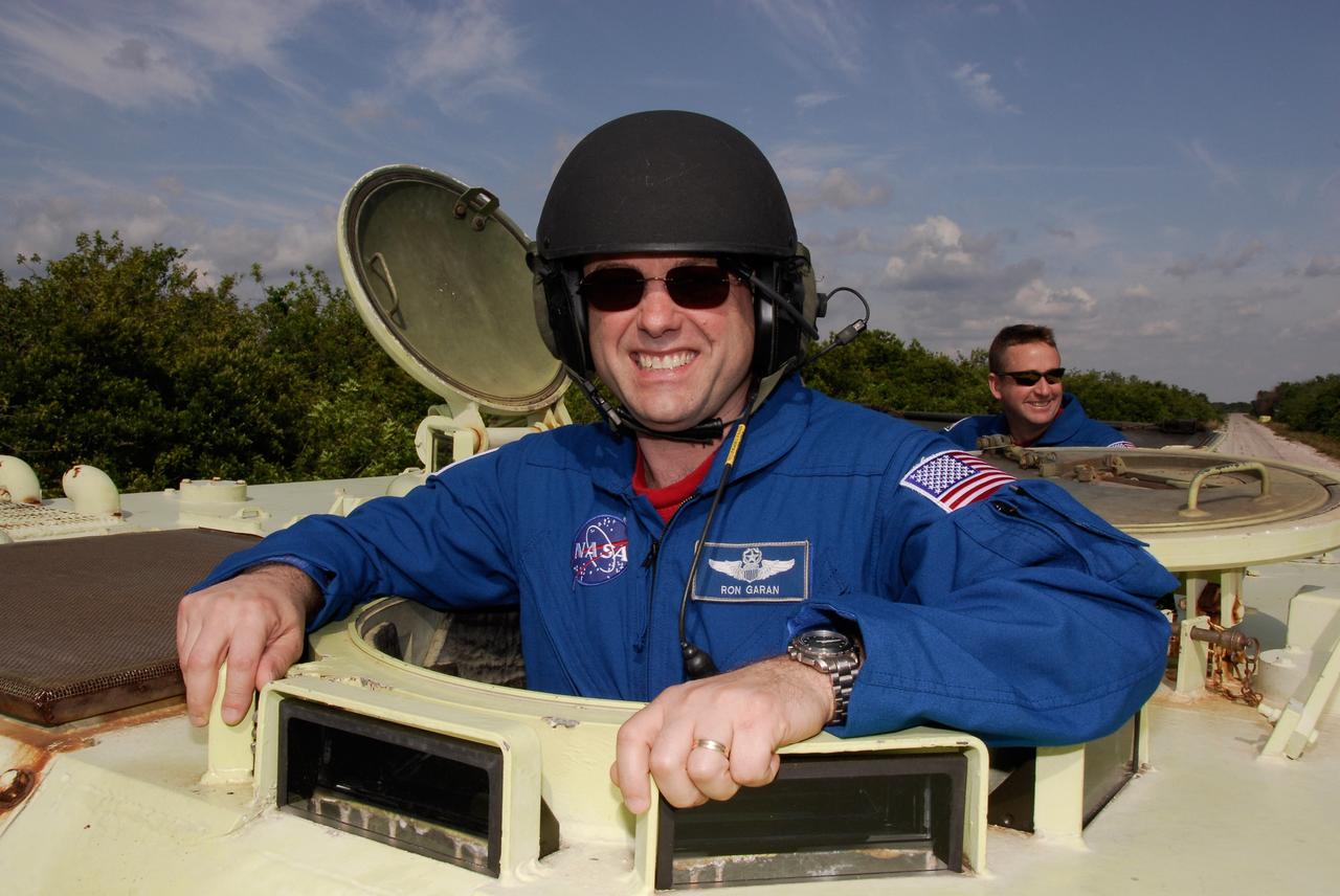 CAPE CANAVERAL, Fla. -- STS-124 Mission Specialist Ron Garan is ready to drive the M113 armored personnel carrier as part of emergency training. Behind him is Pilot Ken Ham. They and other crew members are at NASA's Kennedy Space Center for a dress launch rehearsal called the terminal countdown demonstration test. TCDT provides astronauts and ground crews with an opportunity to participate in various simulated countdown activities, including equipment familiarization and emergency training. On the STS-124 mission, the crew will deliver and install the Japanese Experiment Module – Pressurized Module and Japanese Remote Manipulator System. Discovery's launch is targeted for May 31. Photo credit: NASA/Kim Shiflett