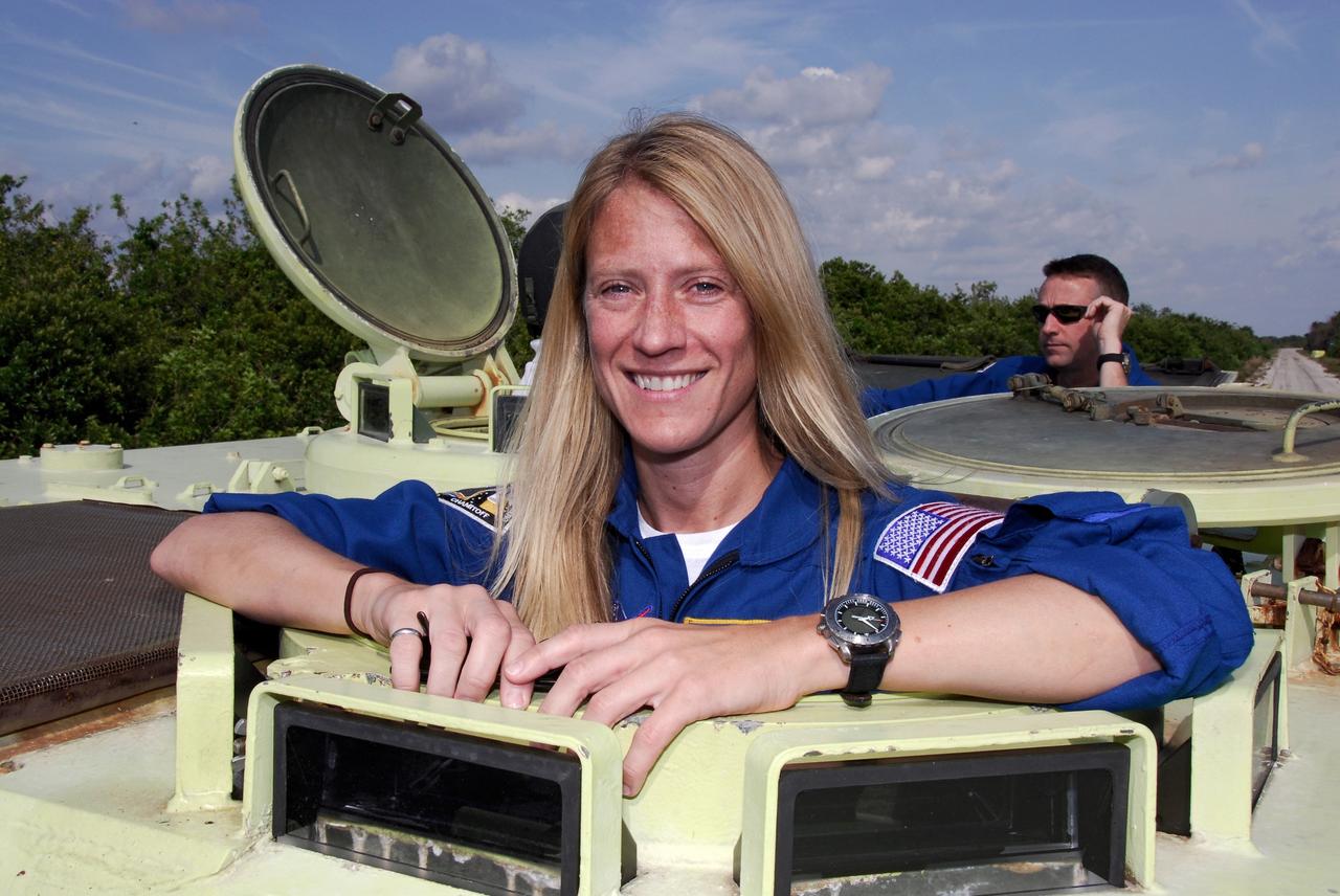 CAPE CANAVERAL, Fla. -- STS-124 Mission Specialist Karen Nyberg is ready to begin driving practice in the M113 armored personnel carrier, part of emergency training. Behind her is Pilot Ken Ham. She and other crew members are at NASA's Kennedy Space Center for a dress launch rehearsal called the terminal countdown demonstration test. TCDT provides astronauts and ground crews with an opportunity to participate in various simulated countdown activities, including equipment familiarization and emergency training. On the STS-124 mission, the crew will deliver and install the Japanese Experiment Module – Pressurized Module and Japanese Remote Manipulator System. Discovery's launch is targeted for May 31. Photo credit: NASA/Kim Shiflett