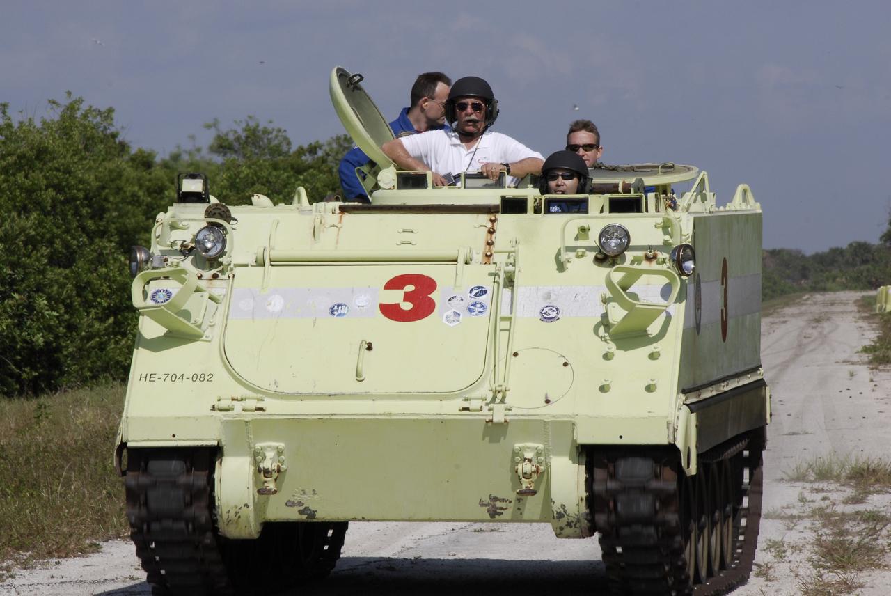 CAPE CANAVERAL, Fla. -- STS-124 Mission Specialist Akihiko Hoshide drives the M113 armored personnel carrier as part of emergency training. Battalion Chief George Hoggard provides supervision. Behind them are Mission Specialist Ron Garan and Pilot Ken Ham. Hoshide and other crew members are at NASA's Kennedy Space Center for a dress launch rehearsal called the terminal countdown demonstration test. TCDT provides astronauts and ground crews with an opportunity to participate in various simulated countdown activities, including equipment familiarization and emergency training. On the STS-124 mission, the crew will deliver and install the Japanese Experiment Module – Pressurized Module and Japanese Remote Manipulator System. Discovery's launch is targeted for May 31. Photo credit: NASA/Kim Shiflett