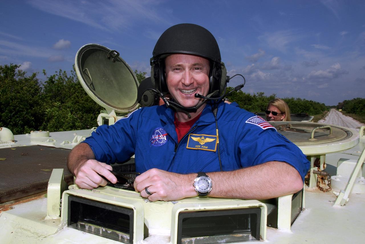 CAPE CANAVERAL, Fla. -- STS-124 Pilot Ken Ham stands ready to practice driving the M113 armored personnel carrier as part of emergency training. Behind him is Mission Specialist Karen Nyberg. Ham and other crew members are at NASA's Kennedy Space Center for a dress launch rehearsal called the terminal countdown demonstration test. TCDT provides astronauts and ground crews with an opportunity to participate in various simulated countdown activities, including equipment familiarization and emergency training. On the STS-124 mission, the crew will deliver and install the Japanese Experiment Module – Pressurized Module and Japanese Remote Manipulator System. Discovery's launch is targeted for May 31. Photo credit: NASA/Kim Shiflett