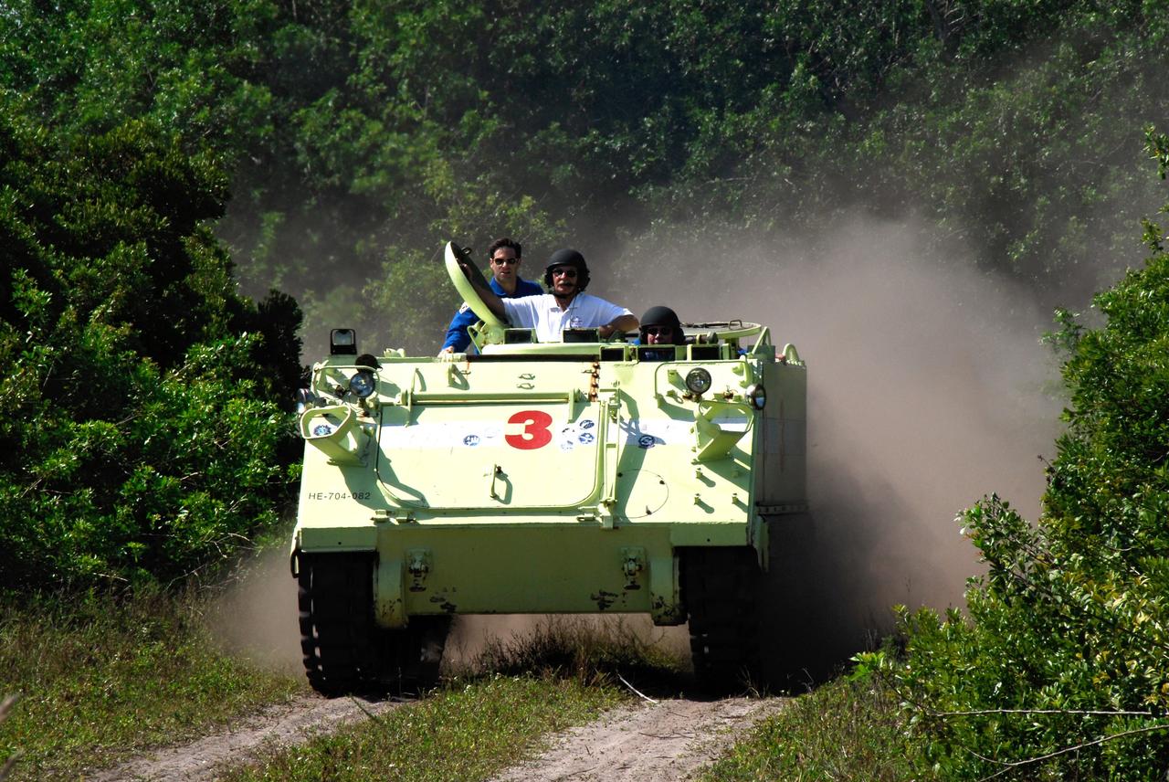 CAPE CANAVERAL, Fla. -- STS-124 Mission Specialist Mike Fossum drives the M113 armored personnel carrier as part of emergency training. Behind him at left is Mission Specialist Greg Chamitoff. At center is Battalion Chief George Hoggard providing supervision. Fossum and other crew members are at NASA's Kennedy Space Center for a dress launch rehearsal called the terminal countdown demonstration test. TCDT provides astronauts and ground crews with an opportunity to participate in various simulated countdown activities, including equipment familiarization and emergency training. On the STS-124 mission, the crew will deliver and install the Japanese Experiment Module – Pressurized Module and Japanese Remote Manipulator System. Discovery's launch is targeted for May 31. Photo credit: NASA/Kim Shiflett