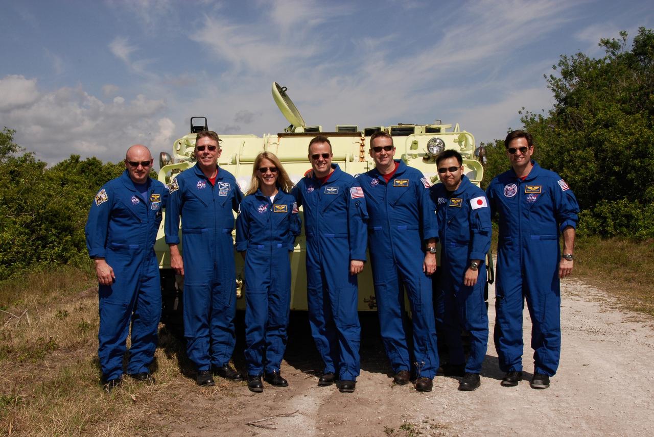 CAPE CANAVERAL, Fla. -- After completing M113 driving practice, the STS-124 crew stands in front of the armored personnel carrier for a photo. From left are Commander Mark Kelly, Mission Specialists Mike Fossum, Karen Nyberg and Ron Garan, Pilot Ken Ham, and Mission Specialists Akihiko Hoshide and Greg Chamitoff. They are at NASA's Kennedy Space Center for a dress launch rehearsal called the terminal countdown demonstration test. TCDT provides astronauts and ground crews with an opportunity to participate in various simulated countdown activities, including equipment familiarization and emergency training. On the STS-124 mission, the crew will deliver and install the Japanese Experiment Module – Pressurized Module and Japanese Remote Manipulator System. Discovery's launch is targeted for May 31. Photo credit: NASA/Kim Shiflett