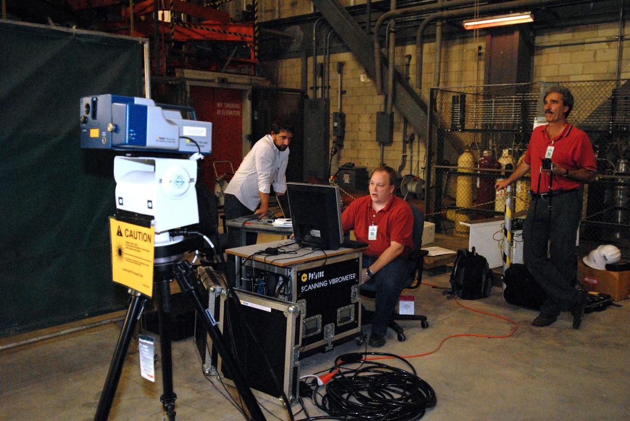 CAPE CANAVERAL, Fla. --  Vibration and laser testing is being conducted on Ares I-X segments at NASA's Kennedy Space Center.  Team members (from left) Ryan Tuttle, with Aerospace Corporation, Jim Gaspar, with NASA's Langley Research Center, and Vaughn Behun, with Langley ATK, execute modal testing using a Laser Vibrometer to collect deflection data from the test article.    Photo credit: NASA/Dimitri Gerondidakis