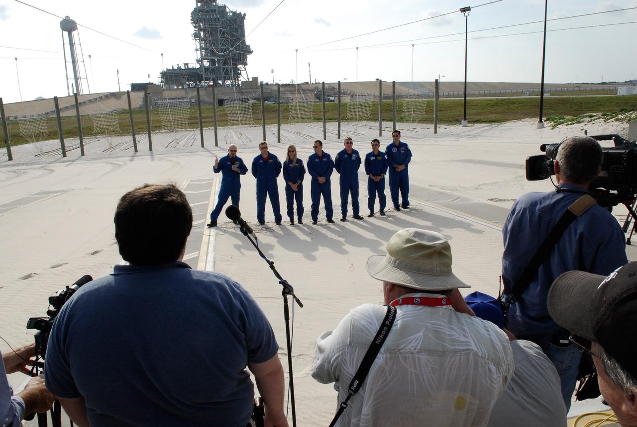 CAPE CANAVERAL, Fla. -- At the slidewire landing area of Launch Pad 39A at NASA's Kennedy Space Center, the STS-124 crew responds to reporters' questions during a media event. Seen from left are Commander Mark Kelly, Pilot Ken Ham, and Mission Specialists Karen Nyberg, Ron Garan, Mike Fossum, Akihiko Hoshide and Greg Chamitoff. Hoshide represents the Japan Aerospace Exploration Agency. In the background is the fixed service structure (center) and the 300-gallon water tower (left). The crew is at Kennedy for a dress launch rehearsal called the terminal countdown demonstration test. TCDT provides astronauts and ground crews with an opportunity to participate in various simulated countdown activities, including equipment familiarization and emergency training. On the STS-124 mission, the crew will deliver and install the Japanese Experiment Module – Pressurized Module and Japanese Remote Manipulator System. Discovery's launch is targeted for May 31. Photo credit: NASA/Kim Shiflett