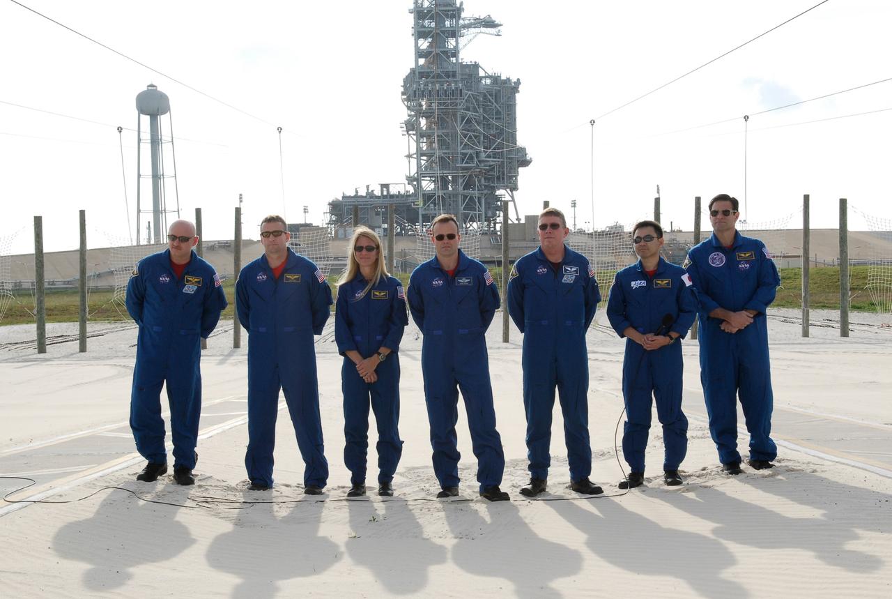 CAPE CANAVERAL, Fla. -- At the slidewire landing area of Launch Pad 39A at NASA's Kennedy Space Center, the STS-124 crew poses for a final group photo following the media question-and-answer event. From left are Commander Mark Kelly, Pilot Ken Ham, and Mission Specialists Karen Nyberg, Ron Garan, Mike Fossum, Akihiko Hoshide and Greg Chamitoff. Hoshide represents the Japan Aerospace Exploration Agency. In the background is the fixed service structure (center) and the 300-gallon water tower (left). The crew is at Kennedy for a dress launch rehearsal called the terminal countdown demonstration test. TCDT provides astronauts and ground crews with an opportunity to participate in various simulated countdown activities, including equipment familiarization and emergency training. On the STS-124 mission, the crew will deliver and install the Japanese Experiment Module – Pressurized Module and Japanese Remote Manipulator System. Discovery's launch is targeted for May 31. Photo credit: NASA/Kim Shiflett