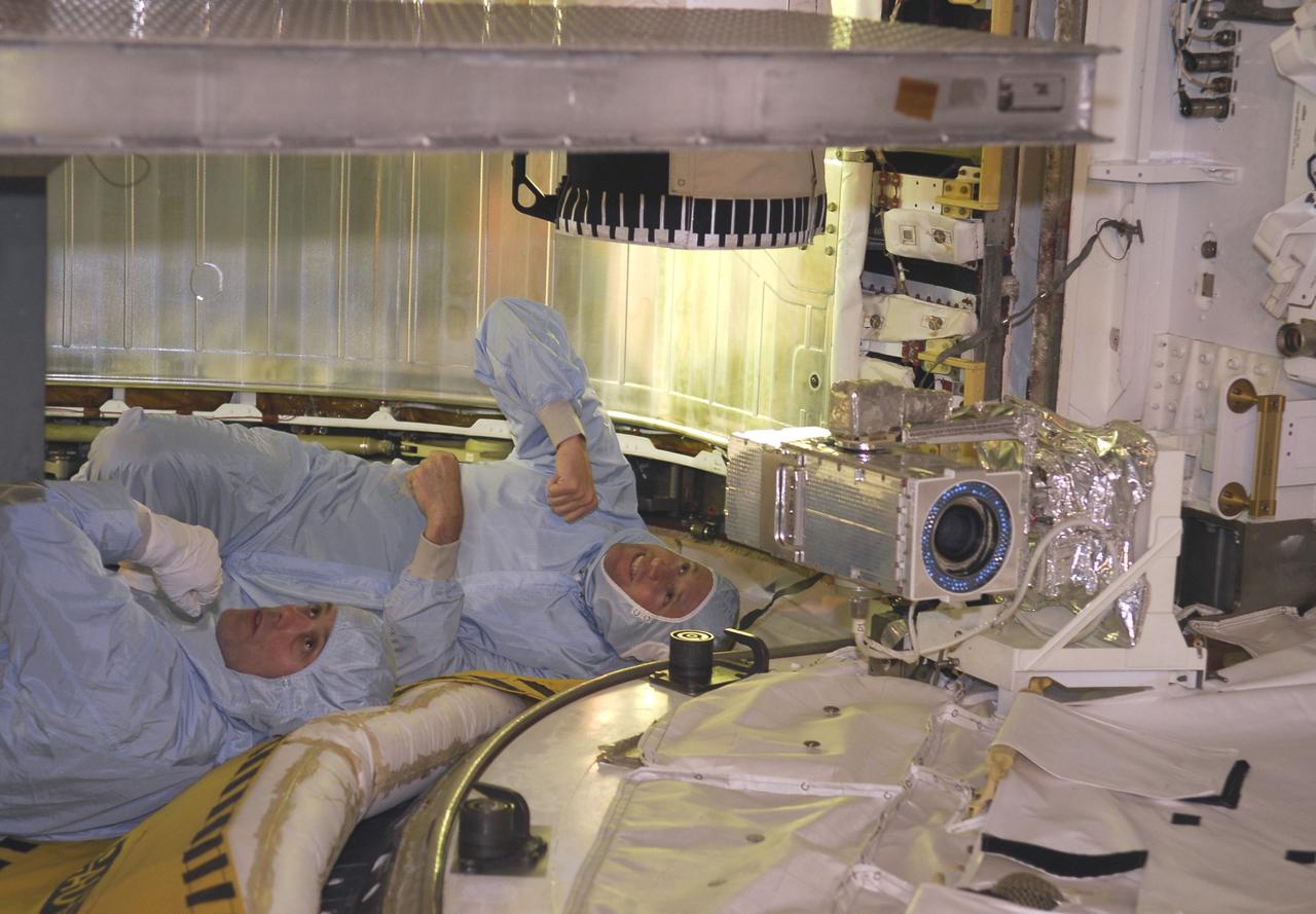 CAPE CANAVERAL, Fla. -- On Launch Pad 39A at NASA's Kennedy Space Center, STS-124 Pilot Ken Ham (right) and Mission Specialist Ron Garan get on their backs for a different view of the payload in space shuttle Discovery's payload bay. The payload bay walkdown is part of the launch dress rehearsal called the terminal countdown demonstration test. TCDT provides astronauts and ground crews with an opportunity to participate in various simulated countdown activities, including equipment familiarization and emergency training. On the STS-124 mission, the crew will deliver and install the Japanese Experiment Module – Pressurized Module and Japanese Remote Manipulator System. Discovery's launch is targeted for May 31. Photo credit: NASA/Kim Shiflett