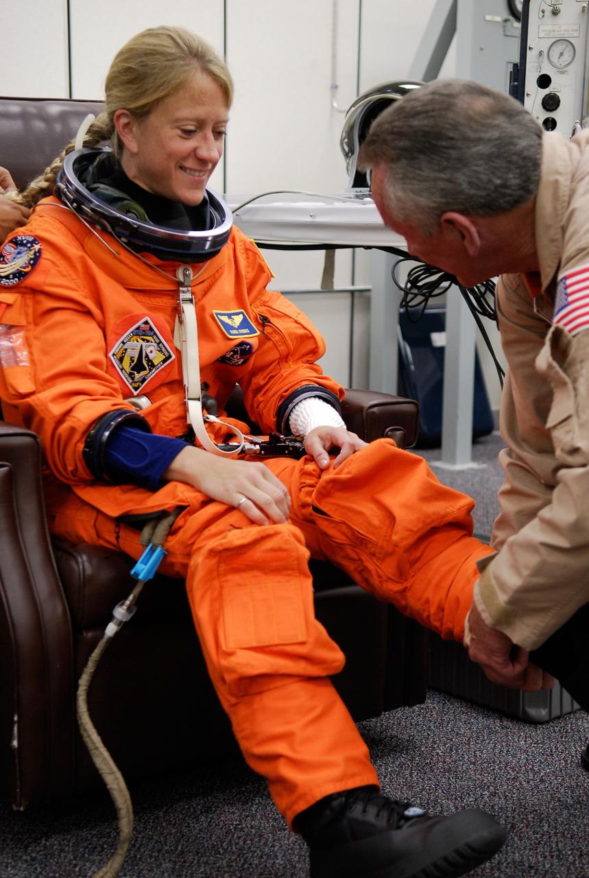 CAPE CANAVERAL, Fla. -- In the Operations and Checkout Building at NASA's Kennedy Space Center, STS-124 Mission Specialist Karen Nyberg gets help donning her launch-and-entry suit for the simulated launch countdown the crew is starting. The simulation is the culmination of the launch dress rehearsal called the terminal countdown demonstration test. TCDT provides astronauts and ground crews with an opportunity to participate in various simulated countdown activities, including equipment familiarization and emergency training. On the STS-124 mission, the crew will deliver and install the Japanese Experiment Module – Pressurized Module and Japanese Remote Manipulator System. Discovery's launch is targeted for May 31. Photo credit: NASA/Kim Shiflett