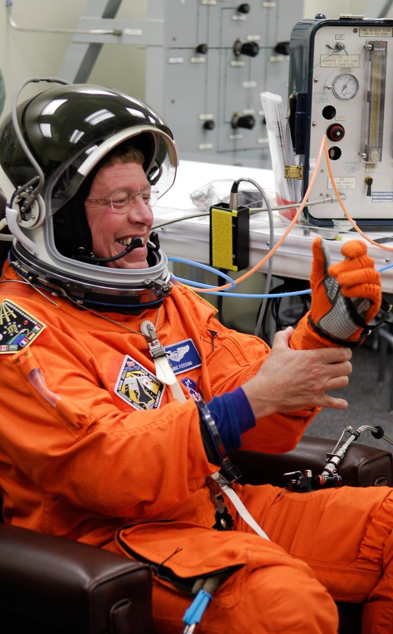 CAPE CANAVERAL, Fla. -- In the Operations and Checkout Building at NASA's Kennedy Space Center, STS-124 Mission Specialist Mike Fossum tests the fit of his glove, part of the launch-and-entry suit needed for the simulated launch countdown. The simulation is the culmination of the launch dress rehearsal called the terminal countdown demonstration test. TCDT provides astronauts and ground crews with an opportunity to participate in various simulated countdown activities, including equipment familiarization and emergency training. On the STS-124 mission, the crew will deliver and install the Japanese Experiment Module – Pressurized Module and Japanese Remote Manipulator System. Discovery's launch is targeted for May 31. Photo credit: NASA/Kim Shiflett