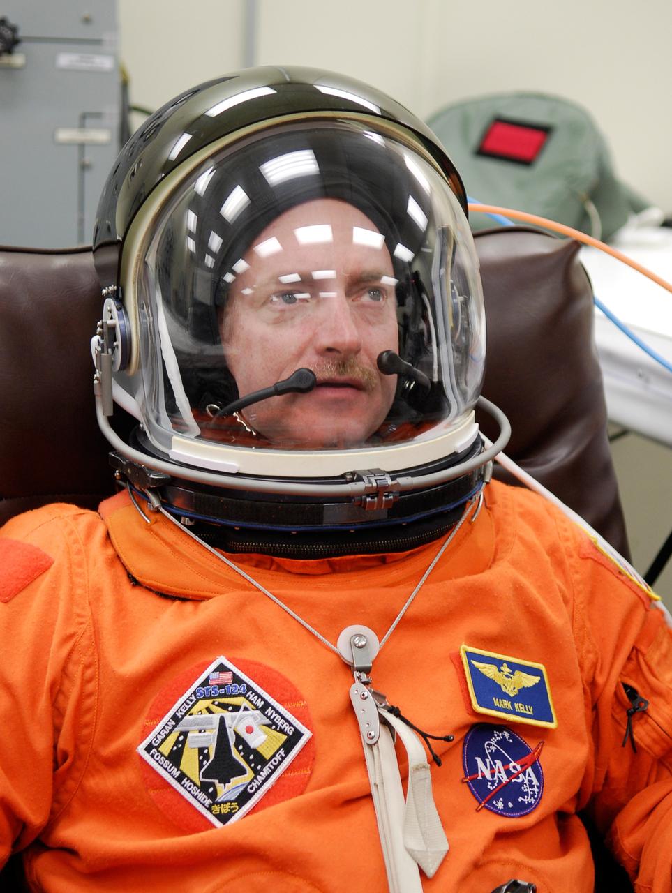 CAPE CANAVERAL, Fla. -- In the Operations and Checkout Building at NASA's Kennedy Space Center, STS-124 Commander Mark Kelly tries on his helmet. The suit fit is part of the simulated launch countdown. The simulation is the culmination of the launch dress rehearsal called the terminal countdown demonstration test. TCDT provides astronauts and ground crews with an opportunity to participate in various simulated countdown activities, including equipment familiarization and emergency training. On the STS-124 mission, the crew will deliver and install the Japanese Experiment Module – Pressurized Module and Japanese Remote Manipulator System. Discovery's launch is targeted for May 31. Photo credit: NASA/Kim Shiflett