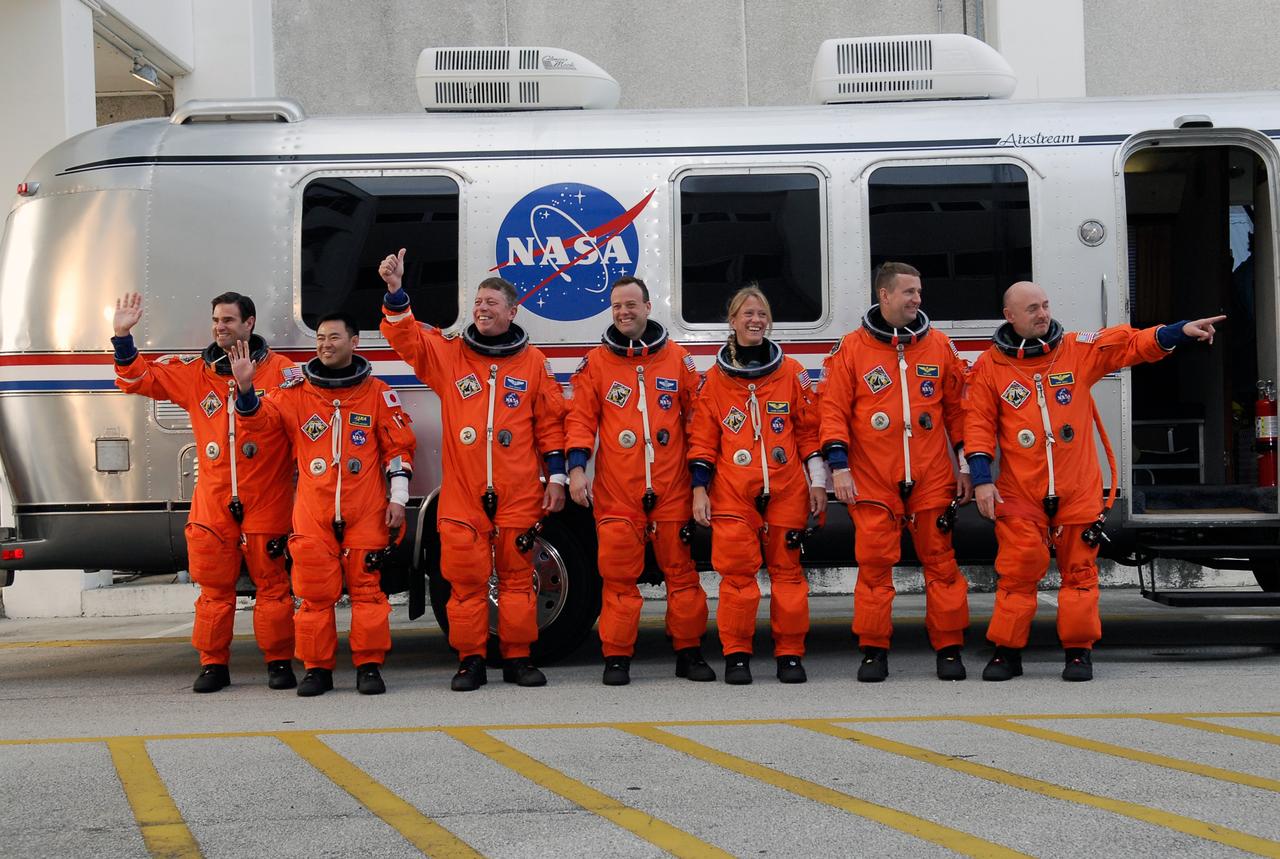 CAPE CANAVERAL, Fla. -- The STS-124 crew pauses in front of the Astrovan to greet spectators before getting on board the Astrovan for the ride to Launch Pad 39A at NASA's Kennedy Space Center. The crew is taking part in a simulated launch countdown. From left are Mission Specialists Greg Chamitoff, Akihiko Hoshide, Mike Fossum, Ron Garan and Karen Nyberg, Pilot Ken Ham, and Commander Mark Kelly. The simulation is part of the launch dress rehearsal called the terminal countdown demonstration test. TCDT provides astronauts and ground crews with an opportunity to participate in various simulated countdown activities, including equipment familiarization and emergency training. On the STS-124 mission, the crew will deliver and install the Japanese Experiment Module – Pressurized Module and Japanese Remote Manipulator System. Discovery's launch is targeted for May 31. Photo credit: NASA/Kim Shiflett