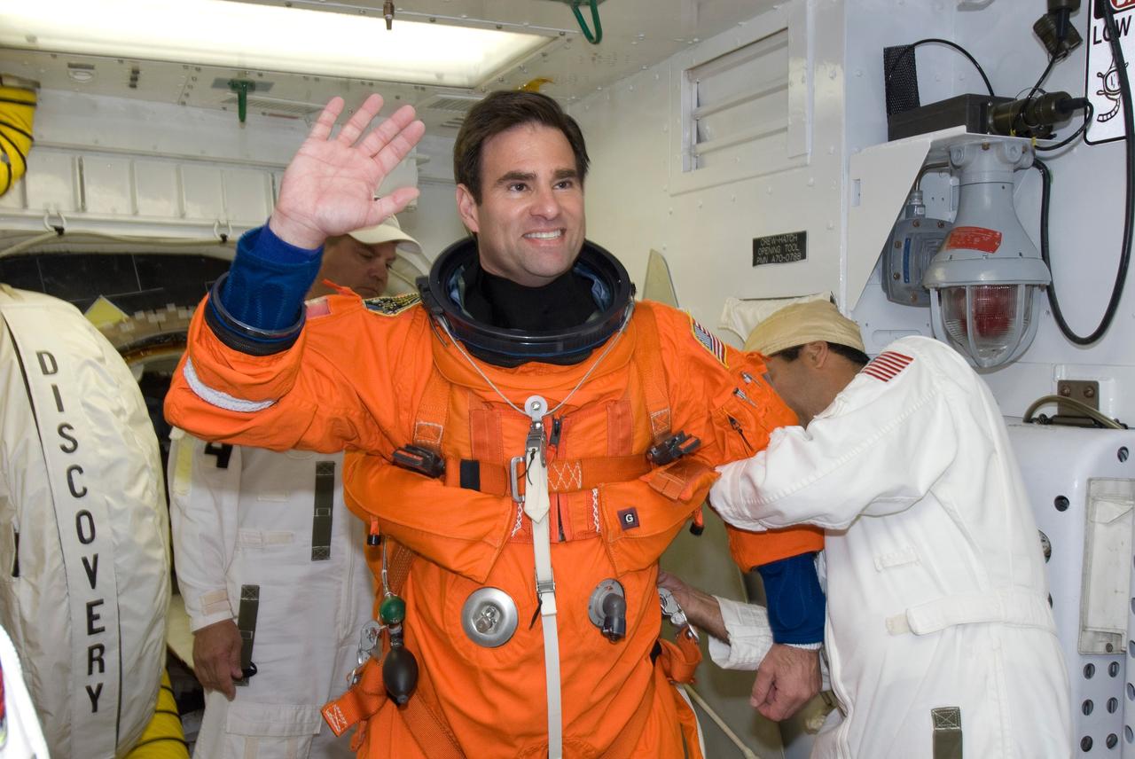 CAPE CANAVERAL, Fla. --  In the White Room on Launch Pad 39A at NASA's Kennedy Space Center, STS-124 Mission Specialist Greg Chamitoff dons the parachute required for launch.  He and the other crew members are taking part in a simulated launch countdown, part of the launch dress rehearsal known as the terminal countdown demonstration test. The simulation serves as a practice exercise in which both the launch team and flight crew rehearse launch day time lines and procedures. The test culminates in a simulated ignition and automated shutdown of the orbiter's main engines.  On the STS-124 mission, the crew will deliver and install the Japanese Experiment Module – Pressurized Module and Japanese Remote Manipulator System.  Discovery's launch is targeted for May 31.  Photo credit: NASA/Amanda Diller