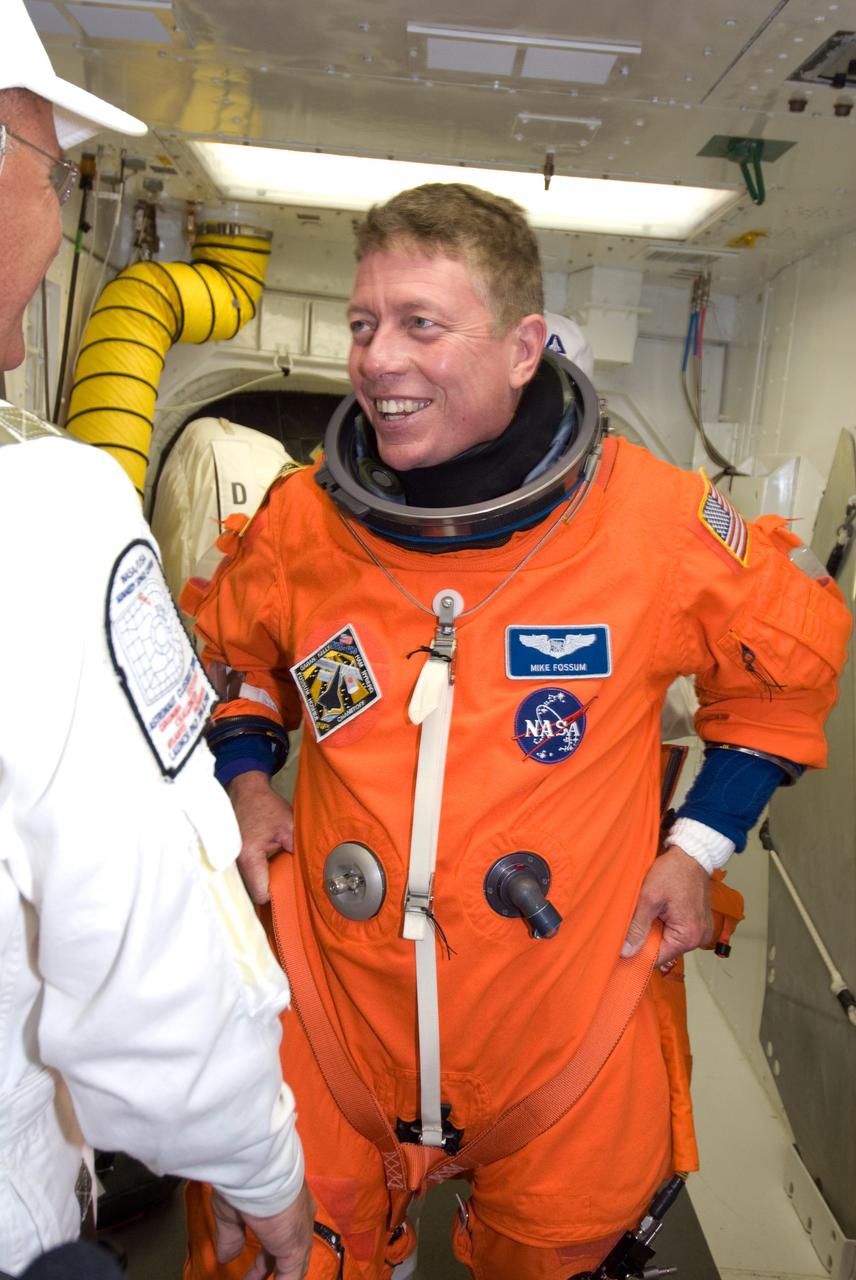CAPE CANAVERAL, Fla. --  In the White Room on Launch Pad 39A at NASA's Kennedy Space Center, STS-124 Mission Specialist Mike Fossum adjusts the parachute he donned for launch.  He and the other crew members are taking part in a simulated launch countdown, part of the launch dress rehearsal known as the terminal countdown demonstration test.  The simulation serves as a practice exercise in which both the launch team and flight crew rehearse launch day time lines and procedures. The test culminates in a simulated ignition and automated shutdown of the orbiter's main engines.  On the STS-124 mission, the crew will deliver and install the Japanese Experiment Module – Pressurized Module and Japanese Remote Manipulator System.  Discovery's launch is targeted for May 31.  Photo credit: NASA/Amanda Diller