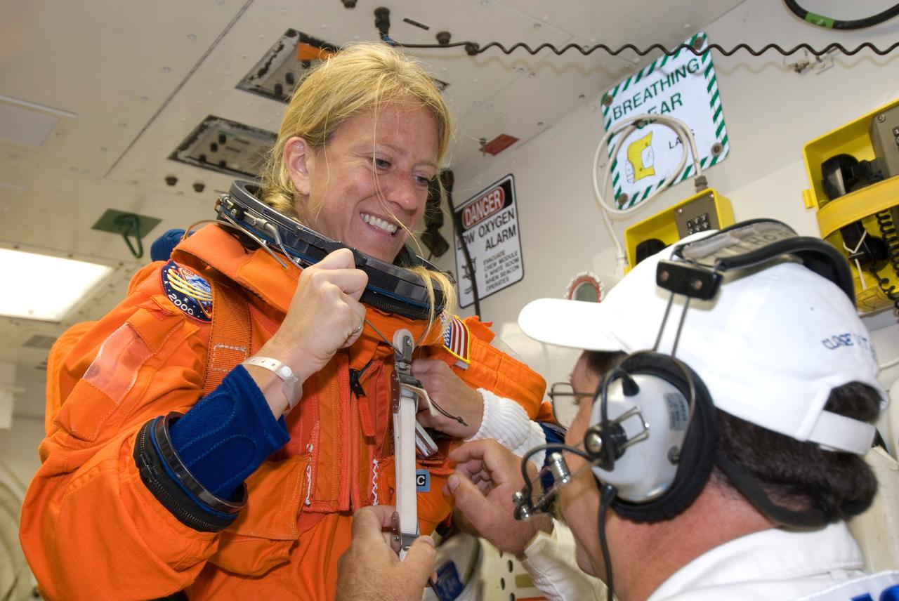 CAPE CANAVERAL, Fla. --  In the White Room on Launch Pad 39A at NASA's Kennedy Space Center, STS-124 Mission Specialist Karen Nyberg is helped getting into the parachute required for launch.  She and the other crew members are taking part in a simulated launch countdown, part of the launch dress rehearsal known as the terminal countdown demonstration test.  The simulation serves as a practice exercise in which both the launch team and flight crew rehearse launch day time lines and procedures. The test culminates in a simulated ignition and automated shutdown of the orbiter's main engines.  On the STS-124 mission, the crew will deliver and install the Japanese Experiment Module – Pressurized Module and Japanese Remote Manipulator System.  Discovery's launch is targeted for May 31.  Photo credit: NASA/Amanda Diller