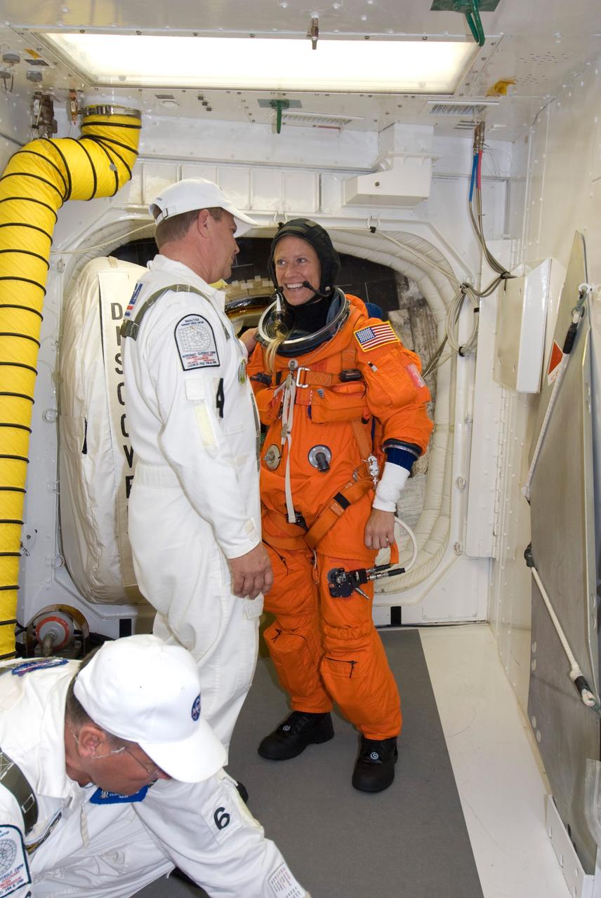 CAPE CANAVERAL, Fla. --  In the White Room on Launch Pad 39A at NASA's Kennedy Space Center, STS-124 Mission Specialist Karen Nyberg chats with one of the closeout crew who is helping her don the equipment required for launch.  She and the other crew members are taking part in a simulated launch countdown, part of the launch dress rehearsal known as the terminal countdown demonstration test. The simulation serves as a practice exercise in which both the launch team and flight crew rehearse launch day time lines and procedures. The test culminates in a simulated ignition and automated shutdown of the orbiter's main engines.  On the STS-124 mission, the crew will deliver and install the Japanese Experiment Module – Pressurized Module and Japanese Remote Manipulator System.  Discovery's launch is targeted for May 31.  Photo credit: NASA/Amanda Diller