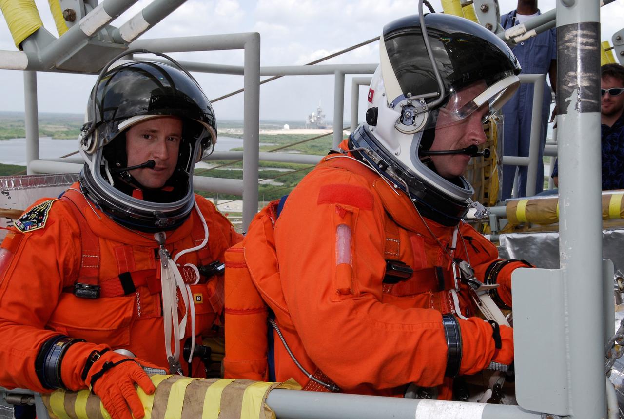 CAPE CANAVERAL, Fla. --  On Launch Pad 39A at NASA's Kennedy Space Center, STS-124 Pilot Ken Ham (left) and Commander Mark Kelly get seated in the slidewire basket on the 195-foot level of the fixed service structure.  The baskets are used for emergency egress, part of the launch dress rehearsal known as the terminal countdown demonstration test. TCDT provides astronauts and ground crews with an opportunity to participate in various simulated countdown activities, including a simulated launch countdown, equipment familiarization and emergency egress training.  On the STS-124 mission, the crew will deliver and install the Japanese Experiment Module – Pressurized Module and Japanese Remote Manipulator System.  Discovery's launch is targeted for May 31.   Photo credit: NASA/Kim Shiflett