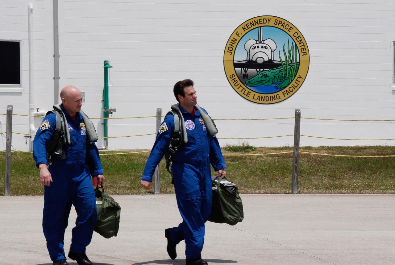 CAPE CANAVERAL, Fla. -- The crew for the STS-124 mission departs NASA's Kennedy Space Center after a successful launch dress rehearsal called the terminal countdown demonstration test. Seen here are Commander Mark Kelly and Mission Specialist Greg Chamitoff heading for the T-38 training jets for their flight back to Houston. The crew is expected to return in late May for the May 31 launch of space shuttle Discovery. On the STS-124 mission, the crew will deliver and install the Japanese Experiment Module – Pressurized Module and Japanese Remote Manipulator System. Photo credit: NASA/Kim Shiflett