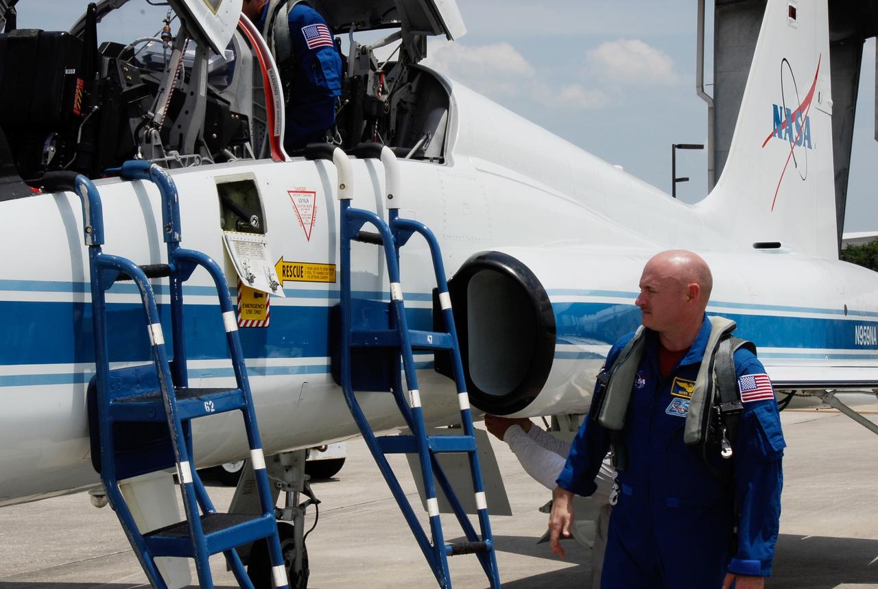 CAPE CANAVERAL, Fla. -- The crew for the STS-124 mission departs NASA's Kennedy Space Center after a successful launch dress rehearsal called the terminal countdown demonstration test. Commander Mark Kelly (right) waits his turn to climb into the cockpit of the T-38 training jet for the flight back to Houston. Mission Specialist Greg Chamitoff is already seated. The crew is expected to return in late May for the May 31 launch of space shuttle Discovery. On the STS-124 mission, the crew will deliver and install the Japanese Experiment Module – Pressurized Module and Japanese Remote Manipulator System. Photo credit: NASA/Kim Shiflett