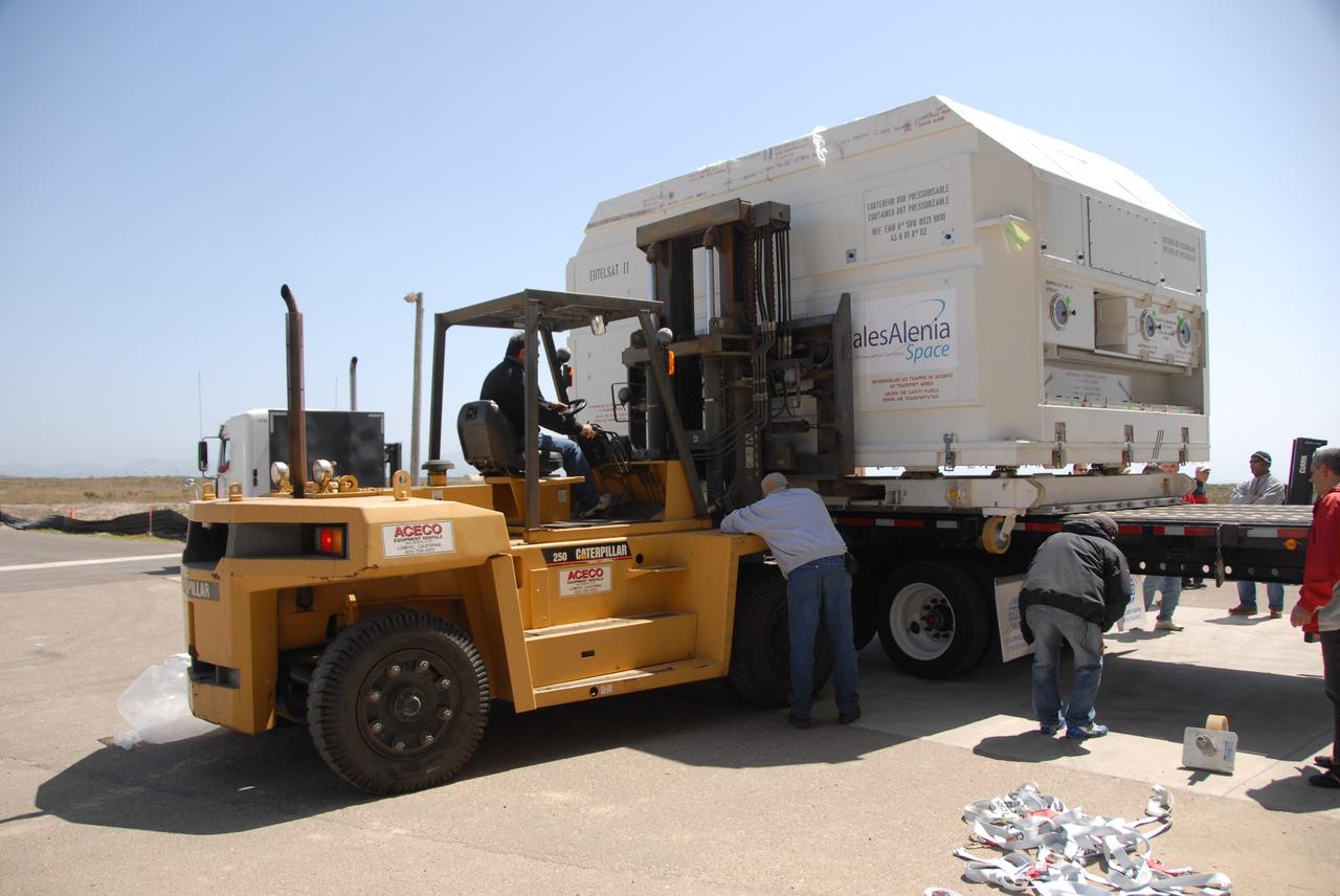 VANDENBERG AIR FORCE BASE, Calif. --  In front of the Astrotech processing facility at Vandenberg Air Force Base, a forklift begins to lift the OSTM/Jason-2 satellite shipping container off the flatbed truck.  The OSTM, or Ocean Topography Mission, on the Jason-2 satellite is a follow-on to Jason-1. It will take oceanographic studies of sea surface height into an operational mode for continued climate forecasting research and science and industrial applications.  This satellite altimetry data will help determine ocean circulation, climate change and sea-level rise. OSTM is a joint effort by the National Oceanic and Atmospheric Administration, NASA, France’s Centre National d’Etudes Spatiales and the European Meteorological Satellite Organisation. OSTM/Jason-2 will be launched aboard a United Launch Alliance Delta II 7320 from Vandenberg on June 15.  Photo credit: NASA/Dan Liberotti