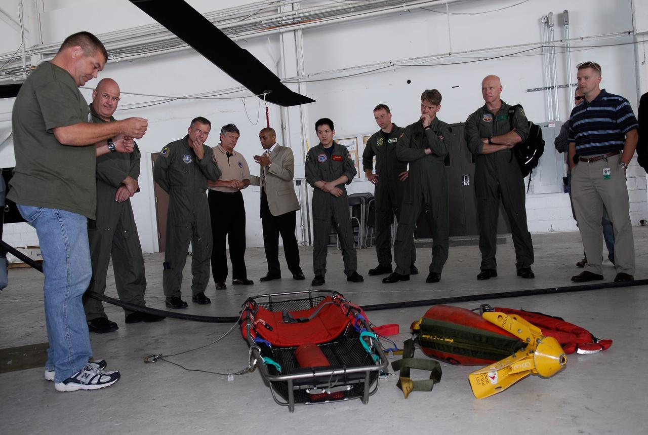 CAPE CANAVERAL, Fla. -- A representative of the 301st Rescue Squadron demonstrates rescue equipment that is used by participants in the Mode VIII exercise being conducted at Patrick Air Force Base, Fla. In support of, and with logistical support from, NASA, USSTRATCOM is hosting a major exercise involving Department of Defense, Department of Homeland Security, search and rescue (SAR) forces, including the 45th Space Wing at Patrick Air Force Base, which support space shuttle astronaut bailout contingency operations, known as Mode VIII. This exercise tests SAR capabilities to locate, recover and provide medical treatment for astronauts following a space shuttle launch phase open-ocean bailout. Participants include members of the U.S. Navy, U.S. Coast Guard, U.S. Air Force, and NASA's Kennedy Space Center and Johnson Space Center. This will be the 15th Mode VIII exercise conducted in the past 20 years. Photo credit: NASA/Kim Shiflett