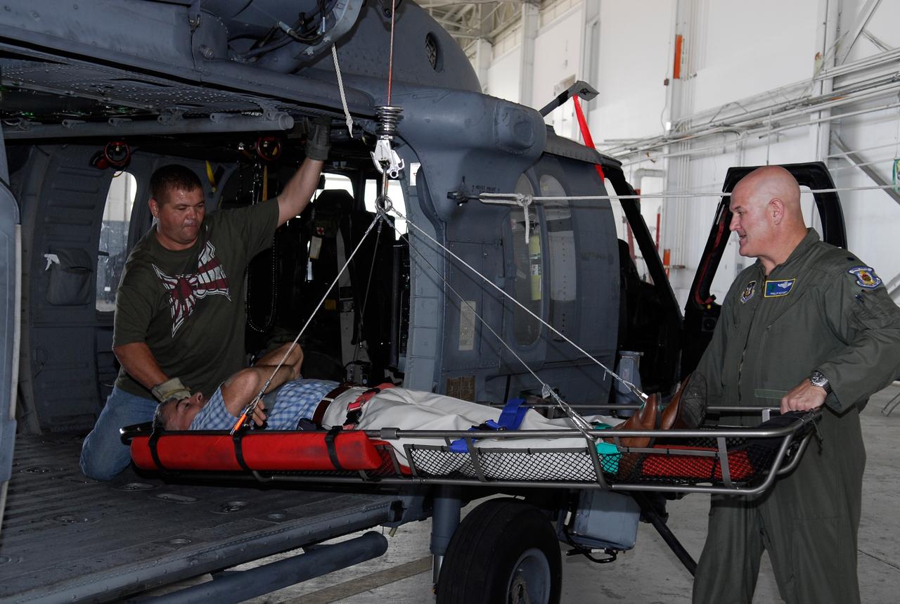 CAPE CANAVERAL, Fla. -- Representatives of the 301st Rescue Squadron demonstrate the use of rescue equipment on the HH-60G helicopter that is used by participants in the Mode VIII exercise being conducted at Patrick Air Force Base, Fla. In support of, and with logistical support from, NASA, USSTRATCOM is hosting a major exercise involving Department of Defense, Department of Homeland Security, search and rescue (SAR) forces, including the 45th Space Wing at Patrick Air Force Base, which support space shuttle astronaut bailout contingency operations, known as Mode VIII. This exercise tests SAR capabilities to locate, recover and provide medical treatment for astronauts following a space shuttle launch phase open-ocean bailout. Participants include members of the U.S. Navy, U.S. Coast Guard, U.S. Air Force, and NASA's Kennedy Space Center and Johnson Space Center. This will be the 15th Mode VIII exercise conducted in the past 20 years. Photo credit: NASA/Kim Shiflett