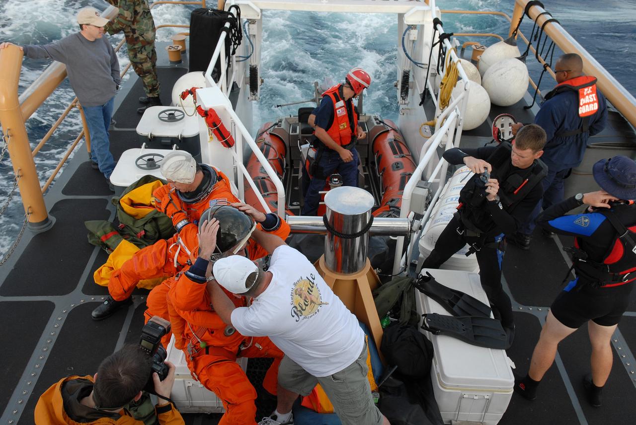 CAPE CANAVERAL, Fla. -- In a U.S. Coast Guard rescue boat off Florida's central east coast, participants in a rescue training exercise, known as Mode VIII, put on astronauts' launch-and-entry suits. In support of, and with logistical support from, NASA, USSTRATCOM is hosting a major exercise involving Department of Defense, Department of Homeland Security, search and rescue (SAR) forces, including the 45th Space Wing at Patrick Air Force Base, which support space shuttle astronaut bailout contingency operations, known as Mode VIII. This exercise tests SAR capabilities to locate, recover and provide medical treatment for astronauts following a space shuttle launch phase open-ocean bailout. Participants include members of the U.S. Navy, U.S. Coast Guard, U.S. Air Force, and NASA's Kennedy Space Center and Johnson Space Center. Photo credit: NASA/Dimitri Gerondidakis