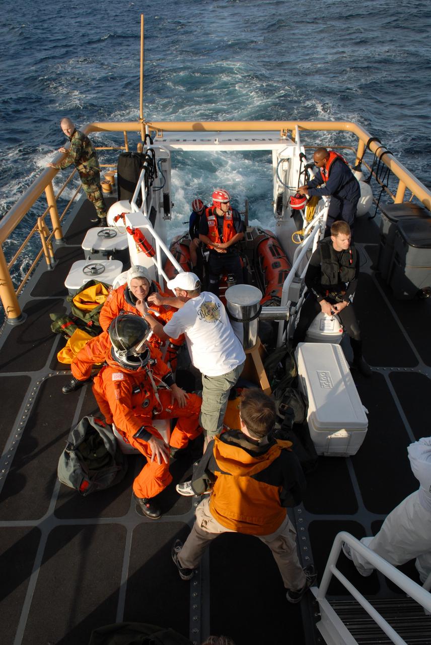 CAPE CANAVERAL, Fla. -- In a U.S. Coast Guard rescue boat off Florida's central east coast, participants in a rescue training exercise, known as Mode VIII, put on astronauts' launch-and-entry suits. In support of, and with logistical support from, NASA, USSTRATCOM is hosting a major exercise involving Department of Defense, Department of Homeland Security, search and rescue (SAR) forces, including the 45th Space Wing at Patrick Air Force Base, which support space shuttle astronaut bailout contingency operations, known as Mode VIII. This exercise tests SAR capabilities to locate, recover and provide medical treatment for astronauts following a space shuttle launch phase open-ocean bailout. Participants include members of the U.S. Navy, U.S. Coast Guard, U.S. Air Force, and NASA's Kennedy Space Center and Johnson Space Center. Photo credit: NASA/Dimitri Gerondidakis