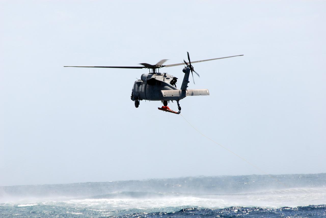 CAPE CANAVERAL, Fla. -- In a rescue training exercise, known as Mode VIII, off Florida's central east coast, an HH-60G helicopter lifts the stretcher bearing a participant. In support of, and with logistical support from, NASA, USSTRATCOM is hosting a major exercise involving Department of Defense, Department of Homeland Security, search and rescue (SAR) forces, including the 45th Space Wing at Patrick Air Force Base, which support space shuttle astronaut bailout contingency operations, known as Mode VIII. This exercise tests SAR capabilities to locate, recover and provide medical treatment for astronauts following a space shuttle launch phase open-ocean bailout. Participants include members of the U.S. Navy, U.S. Coast Guard, U.S. Air Force, and NASA's Kennedy Space Center and Johnson Space Center. Photo credit: NASA/Dimitri Gerondidakis