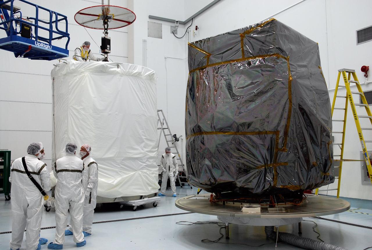 CAPE CANAVERAL, Fla. --   At Astrotech in Titusville, Fla., the wrapped GLAST spacecraft, at right, is ready to be installed into the payload transportation canister, at left.  After installation, the spacecraft will be moved to pad 17-B at Cape Canaveral Air Force Station.  At the pad, NASA's Gamma-Ray Large Area Space Telescope will be lifted into the mobile service tower and encapsulated in the fairing for launch.  GLAST  is a powerful space observatory that will explore the Universe's ultimate frontier, where nature harnesses forces and energies far beyond anything possible on Earth;  probe some of science's deepest questions, such as what our Universe is made of, and search for new laws of physics; explain how black holes accelerate jets of material to nearly light speed; and help crack the mystery of stupendously powerful explosions known as gamma-ray bursts. The launch date is targeted no earlier than June 3.   Photo credit: NASA/Kim Shiflett