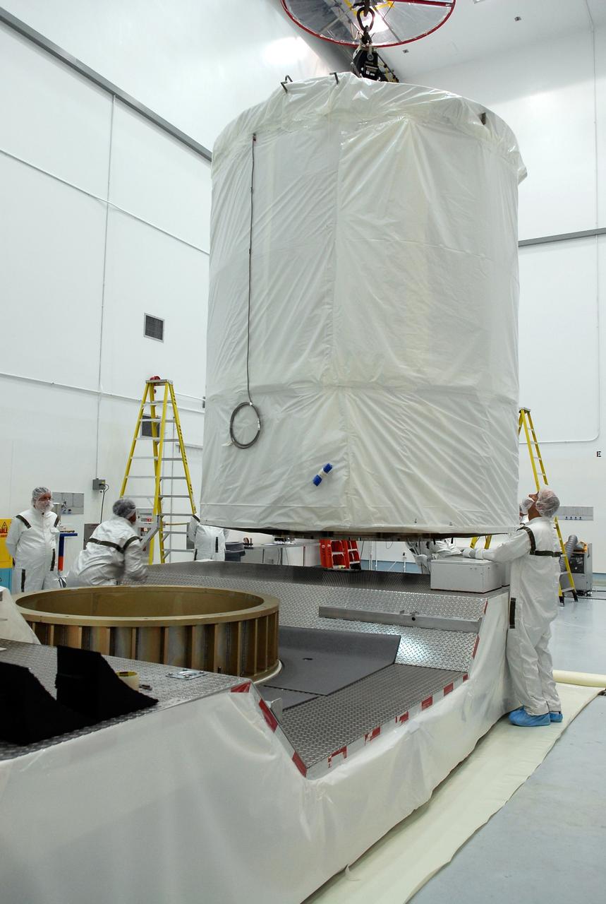 CAPE CANAVERAL, Fla. --  At Astrotech in Titusville, Fla., an overhead crane moves the GLAST spacecraft, inside its payload transportation canister, to the waiting transporter for transfer to pad 17-B at Cape Canaveral Air Force Station.  At the pad, NASA's Gamma-Ray Large Area Space Telescope will be lifted into the mobile service tower and encapsulated in the fairing for launch.  GLAST  is a powerful space observatory that will explore the Universe's ultimate frontier, where nature harnesses forces and energies far beyond anything possible on Earth;  probe some of science's deepest questions, such as what our Universe is made of, and search for new laws of physics; explain how black holes accelerate jets of material to nearly light speed; and help crack the mystery of stupendously powerful explosions known as gamma-ray bursts. The launch date is targeted no earlier than June 3.   Photo credit: NASA/Kim Shiflett