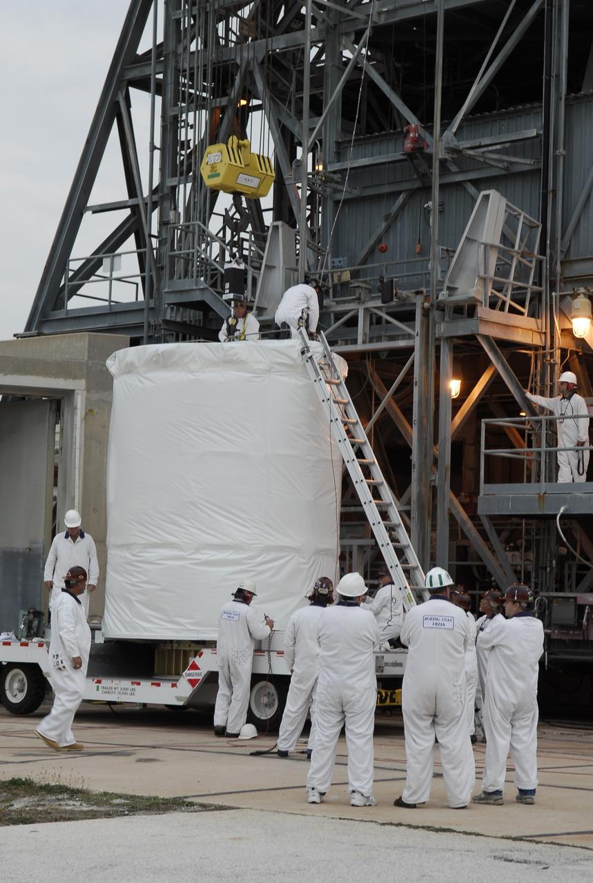 CAPE CANAVERAL, Fla. --  At pad 17-B at Cape Canaveral Air Force Station, workers attach a cable from the hoist to the GLAST spacecraft to lift it into the mobile service tower. GLAST  is a powerful space observatory that will explore the Universe's ultimate frontier, where nature harnesses forces and energies far beyond anything possible on Earth;  probe some of science's deepest questions, such as what our Universe is made of, and search for new laws of physics; explain how black holes accelerate jets of material to nearly light speed; and help crack the mystery of stupendously powerful explosions known as gamma-ray bursts. The launch date is targeted no earlier than June 3.   Photo credit: NASA/Kim Shiflett