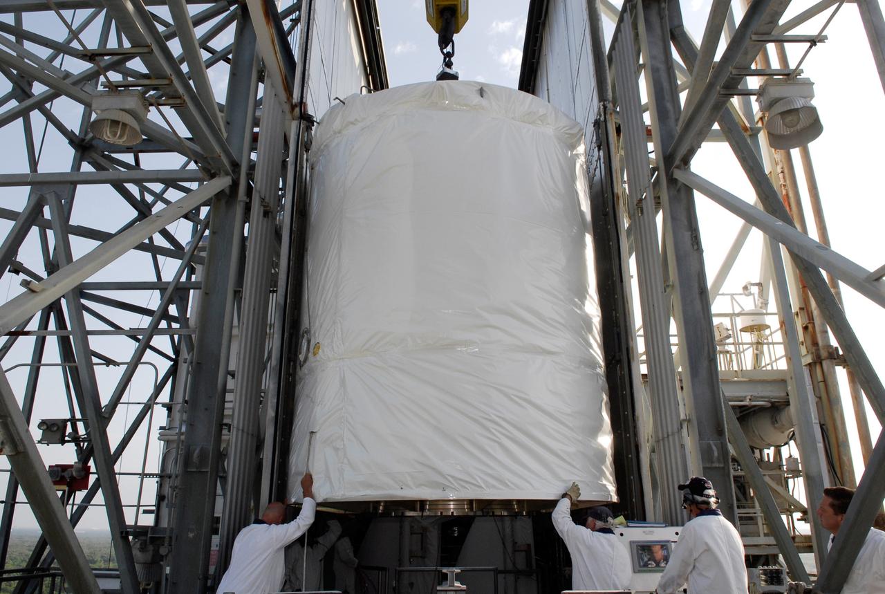 CAPE CANAVERAL, Fla. --  At pad 17-B at Cape Canaveral Air Force Station, workers help maneuver the GLAST spacecraft into the mobile service tower.  In the tower, GLAST will be mated with the Delta II second stage.  GLAST  is a powerful space observatory that will explore the Universe's ultimate frontier, where nature harnesses forces and energies far beyond anything possible on Earth;  probe some of science's deepest questions, such as what our Universe is made of, and search for new laws of physics; explain how black holes accelerate jets of material to nearly light speed; and help crack the mystery of stupendously powerful explosions known as gamma-ray bursts. The launch date is targeted no earlier than June 3.   Photo credit: NASA/Kim Shiflett
