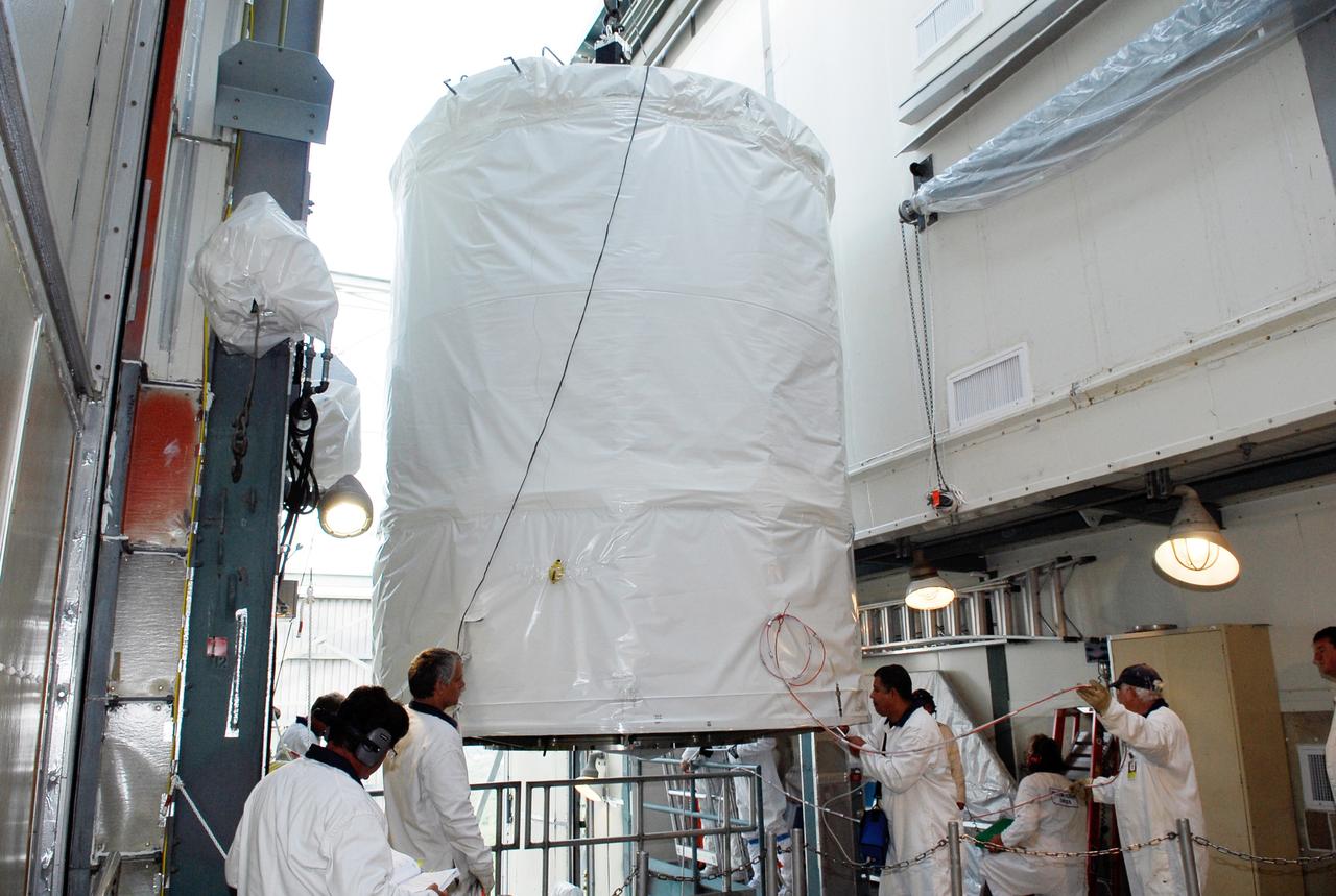 CAPE CANAVERAL, Fla. --  At pad 17-B at Cape Canaveral Air Force Station, workers help maneuver the GLAST spacecraft into the mobile service tower.  In the tower, GLAST will be mated with the Delta II second stage.  GLAST  is a powerful space observatory that will explore the Universe's ultimate frontier, where nature harnesses forces and energies far beyond anything possible on Earth;  probe some of science's deepest questions, such as what our Universe is made of, and search for new laws of physics; explain how black holes accelerate jets of material to nearly light speed; and help crack the mystery of stupendously powerful explosions known as gamma-ray bursts. The launch date is targeted no earlier than June 3.   Photo credit: NASA/Kim Shiflett