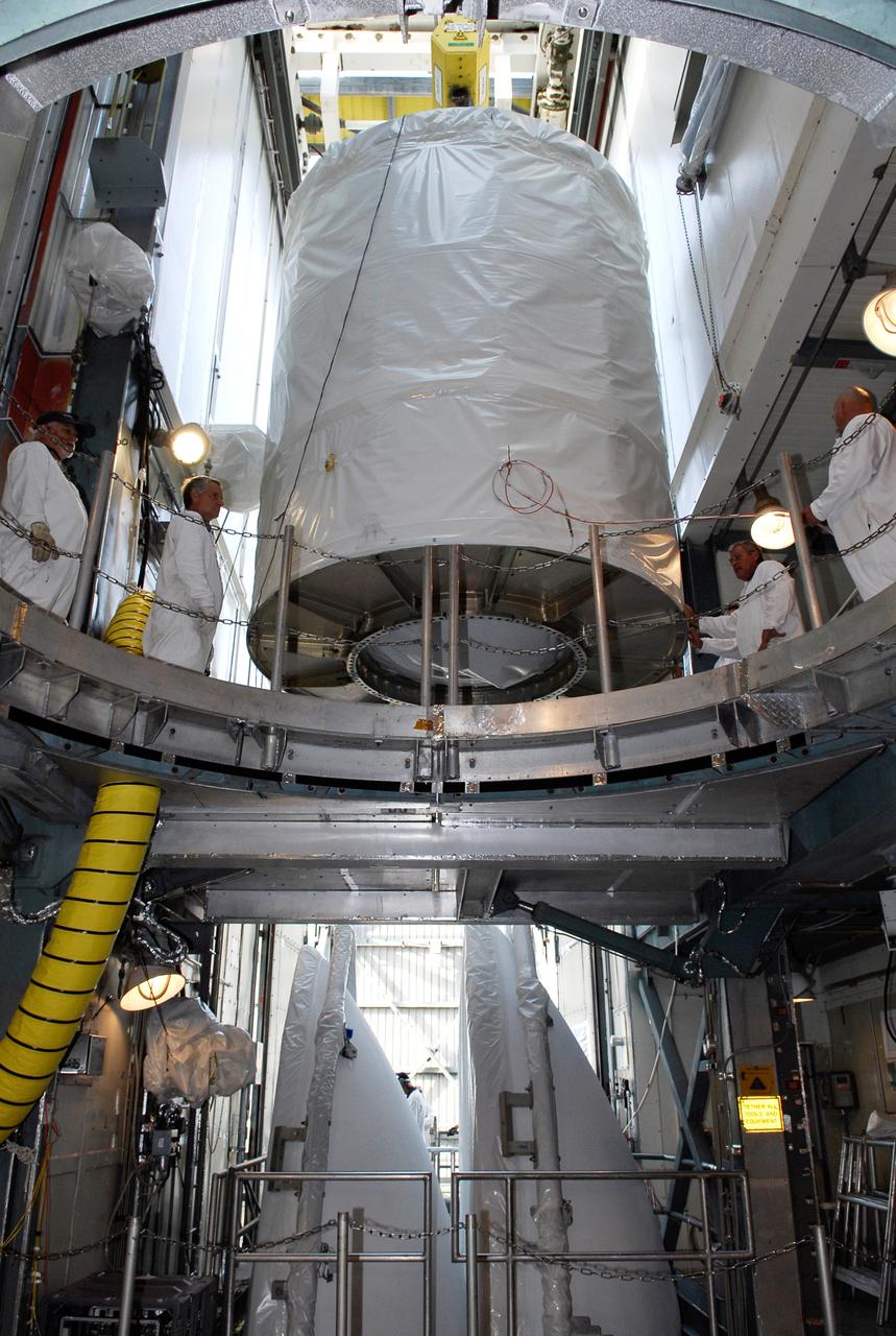 CAPE CANAVERAL, Fla. --  At pad 17-B at Cape Canaveral Air Force Station, workers help maneuver the GLAST spacecraft toward the opening above the Delta II second stage in the mobile service tower.  GLAST will be mated with the Delta II second stage.  GLAST  is a powerful space observatory that will explore the Universe's ultimate frontier, where nature harnesses forces and energies far beyond anything possible on Earth;  probe some of science's deepest questions, such as what our Universe is made of, and search for new laws of physics; explain how black holes accelerate jets of material to nearly light speed; and help crack the mystery of stupendously powerful explosions known as gamma-ray bursts. The launch date is targeted no earlier than June 3.   Photo credit: NASA/Kim Shiflett