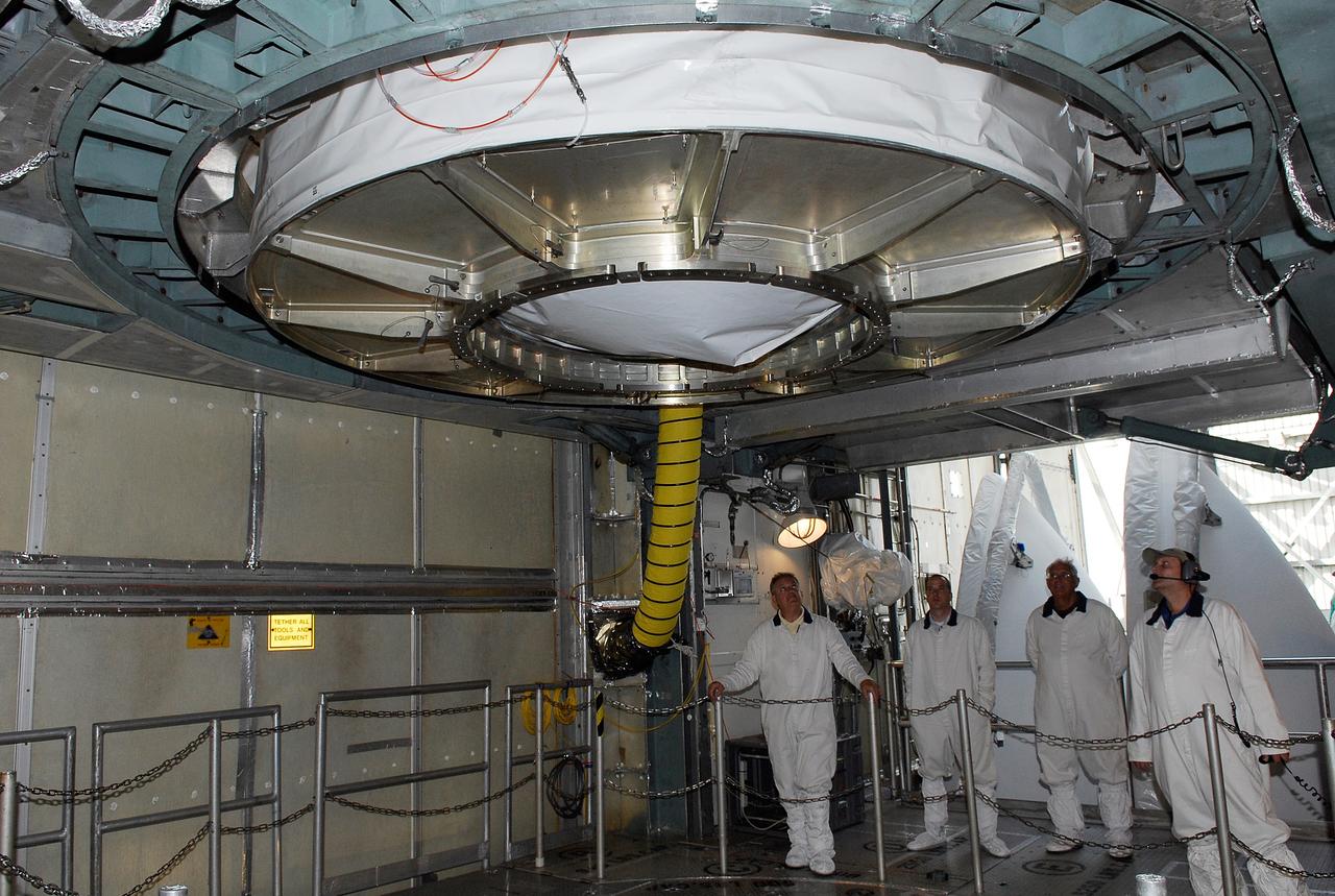CAPE CANAVERAL, Fla. --  At pad 17-B at Cape Canaveral Air Force Station, workers keep watch as the GLAST spacecraft is lowered into the opening above the Delta II second stage in the mobile service tower.  GLAST will be mated with the Delta II second stage.  GLAST  is a powerful space observatory that will explore the Universe's ultimate frontier, where nature harnesses forces and energies far beyond anything possible on Earth;  probe some of science's deepest questions, such as what our Universe is made of, and search for new laws of physics; explain how black holes accelerate jets of material to nearly light speed; and help crack the mystery of stupendously powerful explosions known as gamma-ray bursts. The launch date is targeted no earlier than June 3.   Photo credit: NASA/Kim Shiflett
