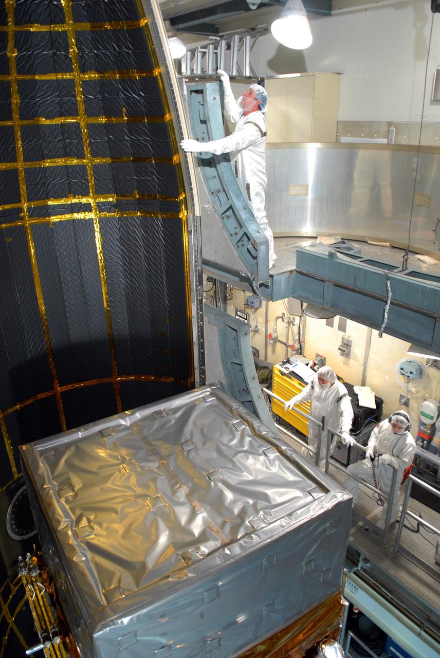 CAPE CANAVERAL, Fla. --  Inside the mobile service tower on Launch Pad 17-B at Cape Canaveral Air Force Station, workers help guide one section of the payload fairing into place around NASA's Gamma-Ray Large Area Space Telescope, or GLAST. The fairing is a molded structure that fits flush with the outside surface of the Delta II upper stage booster and forms an aerodynamically smooth nose cone, protecting the spacecraft during launch and ascent. GLAST  is a powerful space observatory that will explore the Universe's ultimate frontier, where nature harnesses forces and energies far beyond anything possible on Earth;  probe some of science's deepest questions, such as what our Universe is made of, and search for new laws of physics; explain how black holes accelerate jets of material to nearly light speed; and help crack the mystery of stupendously powerful explosions known as gamma-ray bursts. The launch date is targeted no earlier than June 3. Photo credit: NASA/Jim Grossmann
