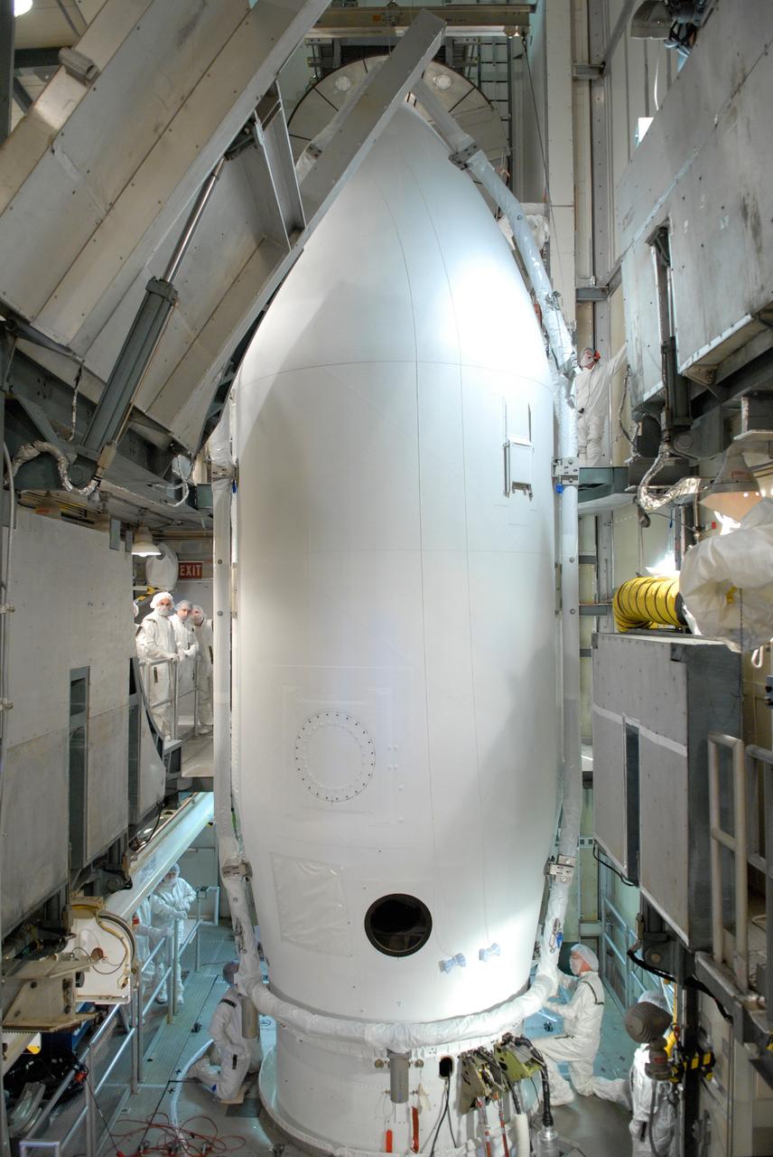 CAPE CANAVERAL, Fla. --   Inside the mobile service tower on Launch Pad 17-B at Cape Canaveral Air Force Station, workers connect the two sections of the payload fairing into place around NASA's Gamma-Ray Large Area Space Telescope, or GLAST. The fairing is a molded structure that fits flush with the outside surface of the Delta II upper stage booster and forms an aerodynamically smooth nose cone, protecting the spacecraft during launch and ascent. GLAST  is a powerful space observatory that will explore the Universe's ultimate frontier, where nature harnesses forces and energies far beyond anything possible on Earth;  probe some of science's deepest questions, such as what our Universe is made of, and search for new laws of physics; explain how black holes accelerate jets of material to nearly light speed; and help crack the mystery of stupendously powerful explosions known as gamma-ray bursts. The launch date is targeted no earlier than June 3. Photo credit: NASA/Jim Grossmann