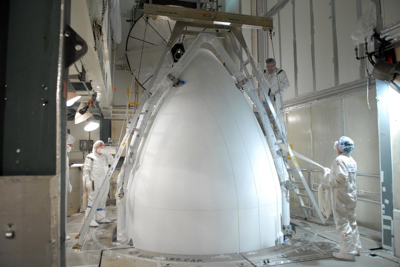 CAPE CANAVERAL, Fla. --   Inside the mobile service tower on Launch Pad 17-B at Cape Canaveral Air Force Station, workers secure the top of the payload fairing into place around NASA's Gamma-Ray Large Area Space Telescope, or GLAST.  The fairing is a molded structure that fits flush with the outside surface of the Delta II upper stage booster and forms an aerodynamically smooth nose cone, protecting the spacecraft during launch and ascent. GLAST  is a powerful space observatory that will explore the Universe's ultimate frontier, where nature harnesses forces and energies far beyond anything possible on Earth;  probe some of science's deepest questions, such as what our Universe is made of, and search for new laws of physics; explain how black holes accelerate jets of material to nearly light speed; and help crack the mystery of stupendously powerful explosions known as gamma-ray bursts. The launch date is targeted no earlier than June 3. Photo credit: NASA/Jim Grossmann