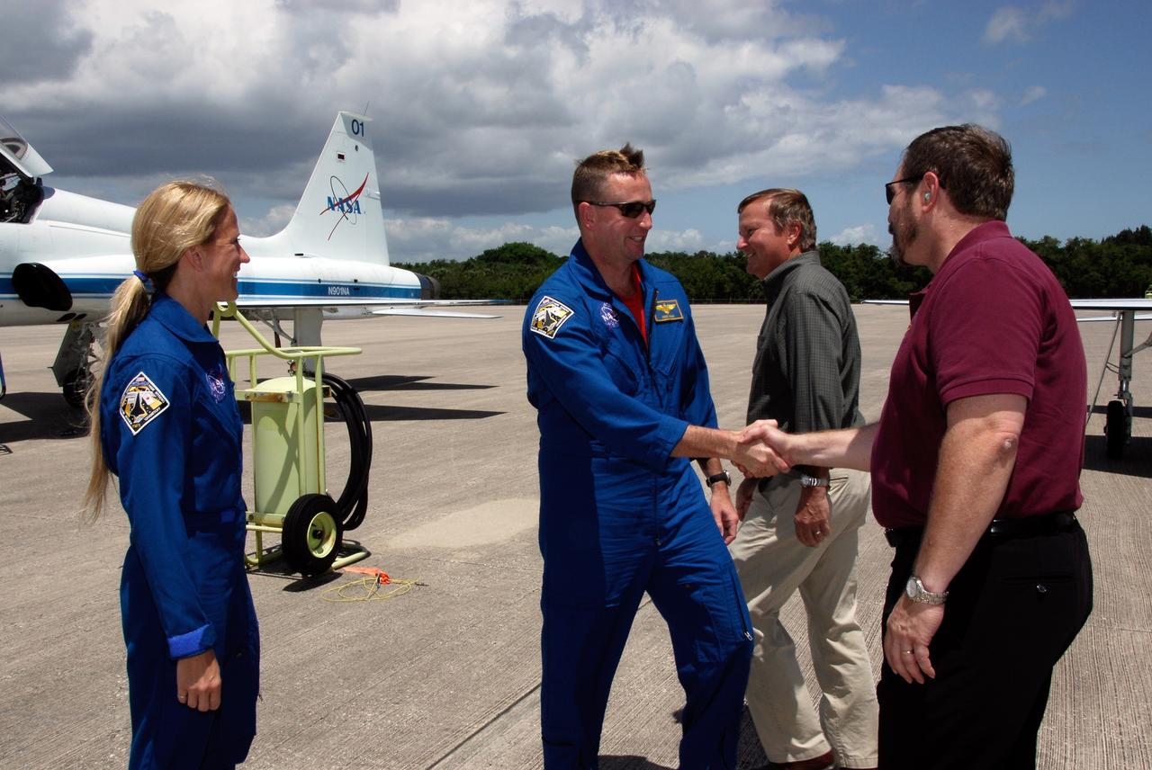 CAPE CANAVERAL, Fla. --  The crew of space shuttle Discovery's STS-124 mission arrives at the Shuttle Landing Facility at NASA's Kennedy Space Center aboard T-38 jet trainers to get ready for launch.  At left is Mission Specialist Karen Nyberg; at center, Pilot Ken Ham is greeted by the director of Launch Vehicle Processing, Mike Wetmore. Behind them is Shuttle Launch Director Mike Leinbach.  Launch of Discovery is scheduled for 5:02 p.m. May 31.  On the STS-124 mission, the crew of seven will deliver and install the Japanese Experiment Module – Pressurized Module and Japanese Remote Manipulator System.  Photo credit: NASA/Kim Shiflett