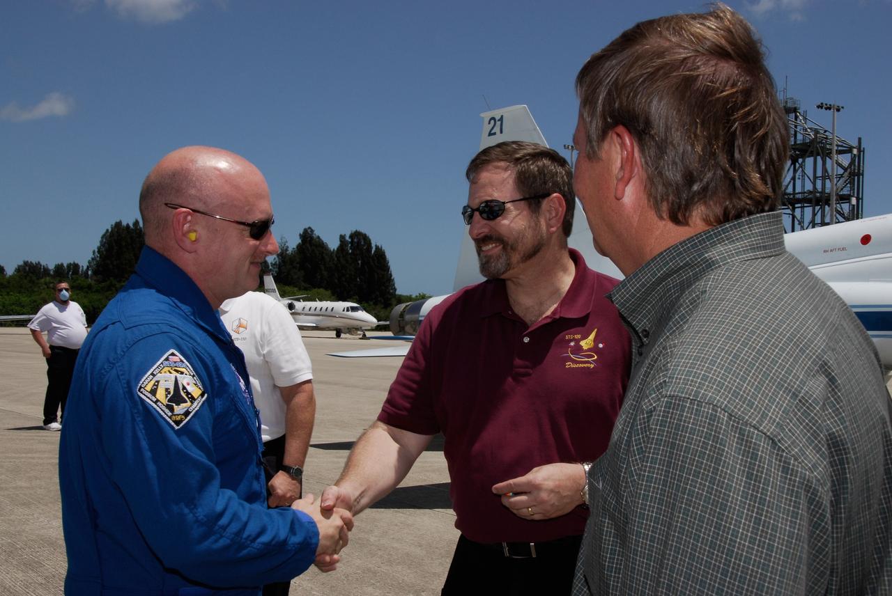 CAPE CANAVERAL, Fla. --   The crew of space shuttle Discovery's STS-124 mission arrives at the Shuttle Landing Facility at NASA's Kennedy Space Center aboard T-38 jet trainers to get ready for launch. From left, Commander Mark Kelly is greeted by the director of Launch Vehicle Processing, Mike Wetmore, and Shuttle Launch Director Mike Leinbach.  Launch of Discovery is scheduled for 5:02 p.m. May 31.  On the STS-124 mission, the crew of seven will deliver and install the Japanese Experiment Module – Pressurized Module and Japanese Remote Manipulator System.  Photo credit: NASA/Kim Shiflett