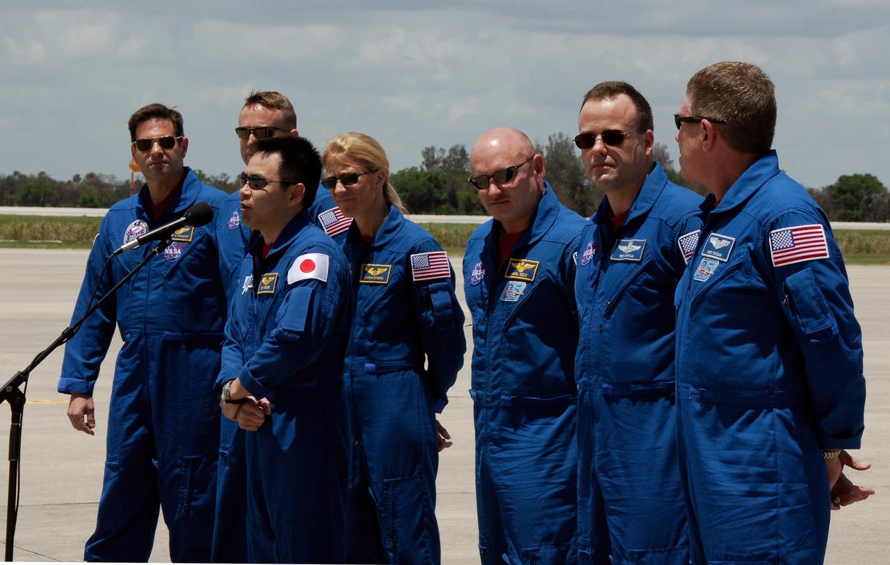 CAPE CANAVERAL, Fla. --  After their arrival on the Shuttle Landing Facility at NASA's Kennedy Space Center, the crew members of space shuttle Discovery's STS-124 mission gather to talk to the media. Seen here at the microphone is Mission Specialist Akihiko Hoshide, who represents the Japan Aerospace Exploration Agency.  Behind him, from left are Mission Specialist Gregory Chamitoff, Pilot Ken Ham, Mission Specialist Karen Nyberg, Commander Mark Kelly, and Mission Specialists Ron Garan and Mike Fossum.  Launch of Discovery is scheduled for 5:02 p.m. May 31.  On the STS-124 mission, the crew of seven will deliver and install the Japanese Experiment Module – Pressurized Module and Japanese Remote Manipulator System.  Photo credit: NASA/Kim Shiflett